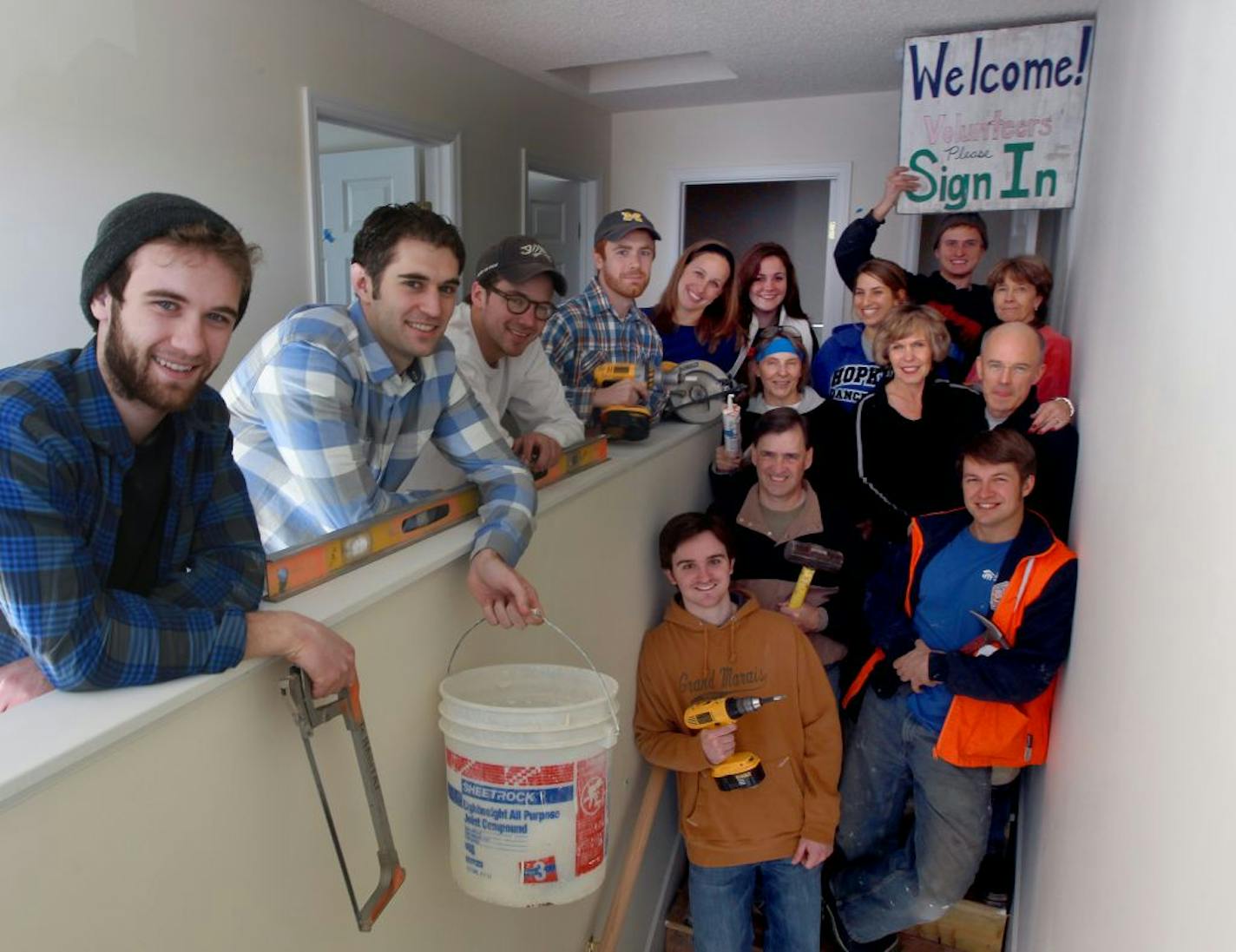 Newlyweds Karen and Lee Newcomer, center, on the stairs, put their newly blended family to work building a home – for another family.