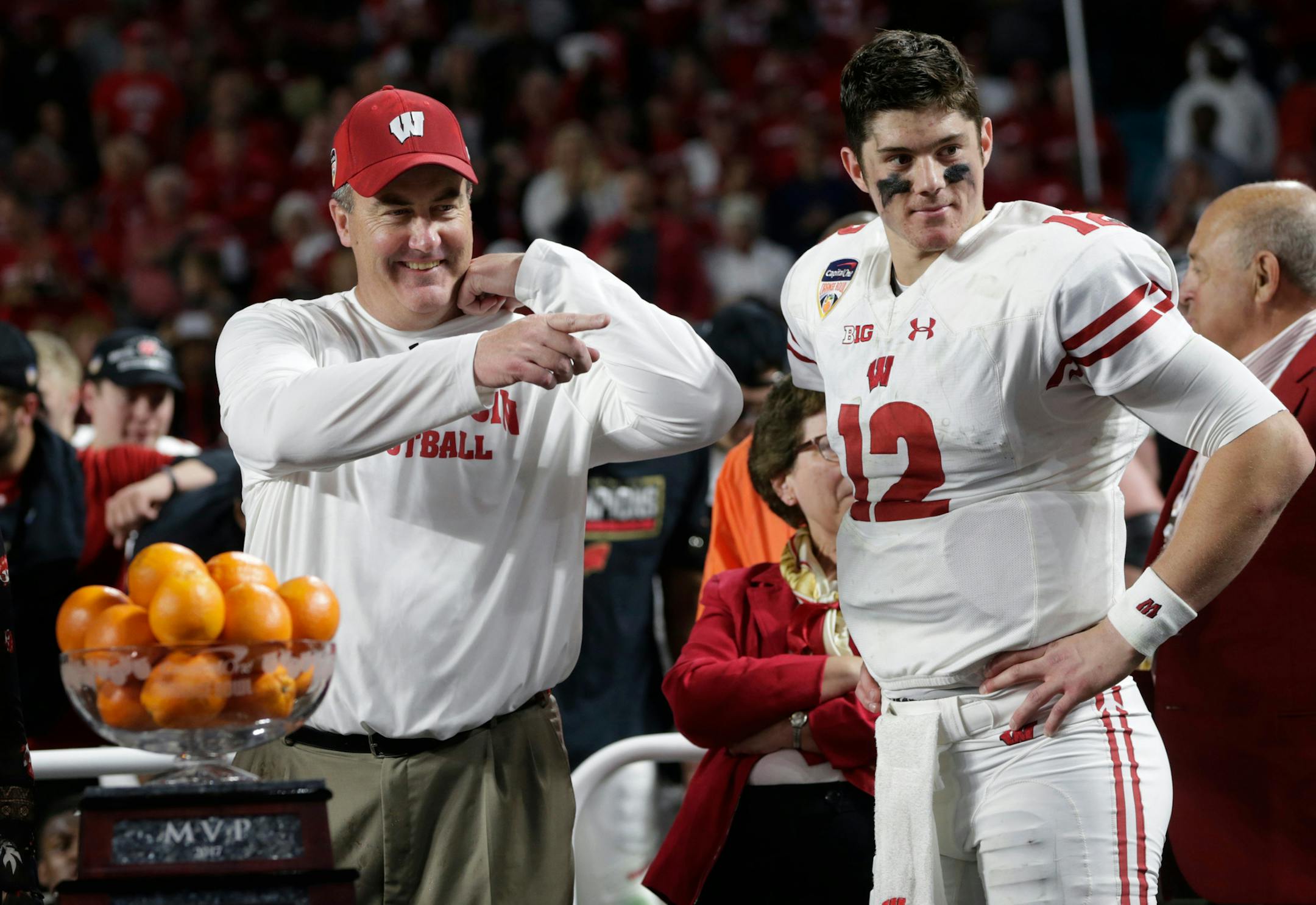 FILE - In this Dec. 30, 2017, file photo, Wisconsin head coach Paul Chryst and quarterback Alex Hornibrook (12) stand next to the MVP trophy at the end of the Orange Bowl NCAA college football game against Miami, in Miami Gardens, Fla. Hornibrook won the MVP trophy. Spring is in the air for the Wisconsin's usually run-first offense. Coach Paul Chryst is letting loose a little bit more in spring practice, which makes sense given quarterback Hornibrook's bowl performance and a stocked receiving co
