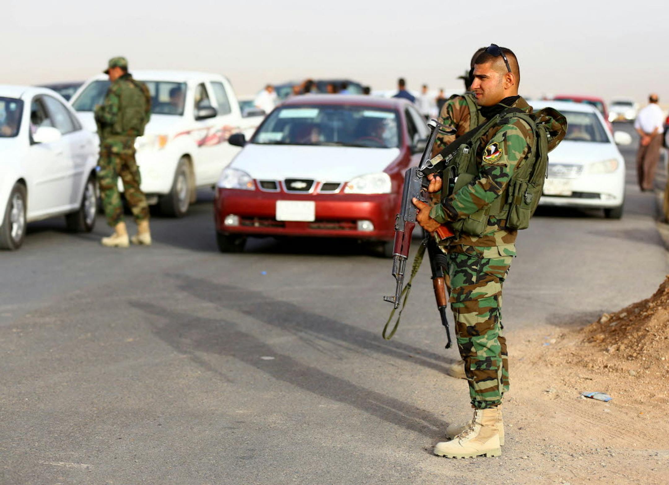 June. 11, 2014: Kurdish policemen stand guard while refugees from Mosul head to the self-ruled northern Kurdish region outside Irbil, 217 miles (350 kilometers) north of Baghdad, Iraq.