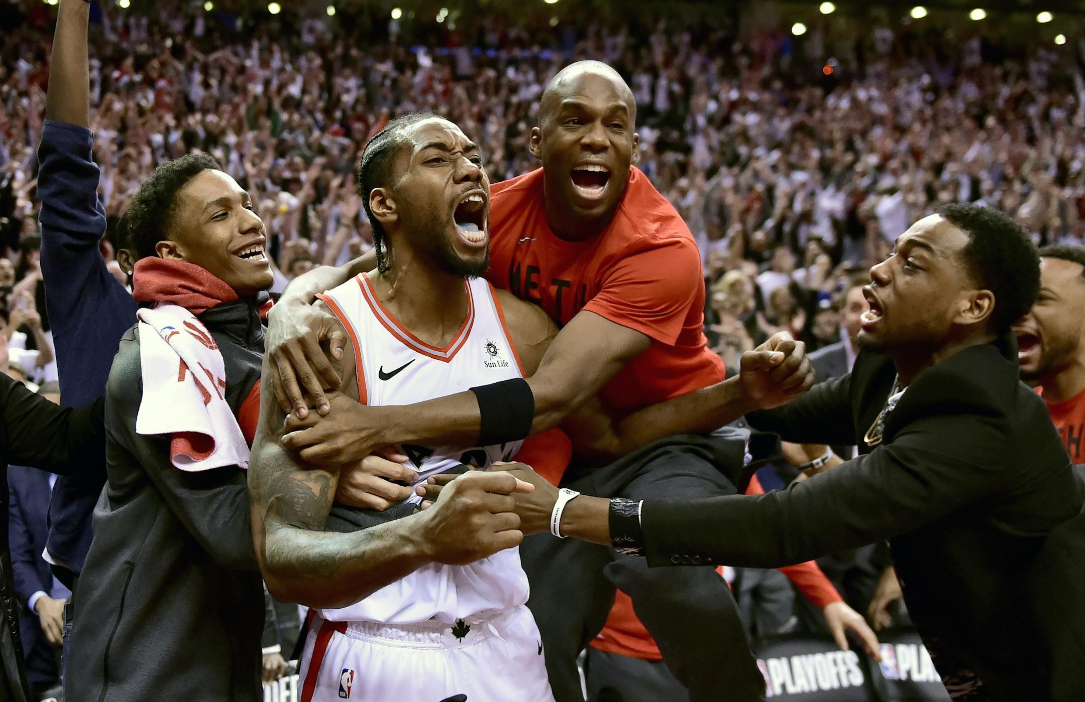 Toronto Raptors forward Kawhi Leonard, second from left, celebrates his game-winning basket as time expired at the end of an NBA Eastern Conference semifinal basketball game against the Philadelphia 76ers, in Toronto on Sunday, May 12, 2019. Toronto won 92-90. (Frank Gunn/The Canadian Press via AP)