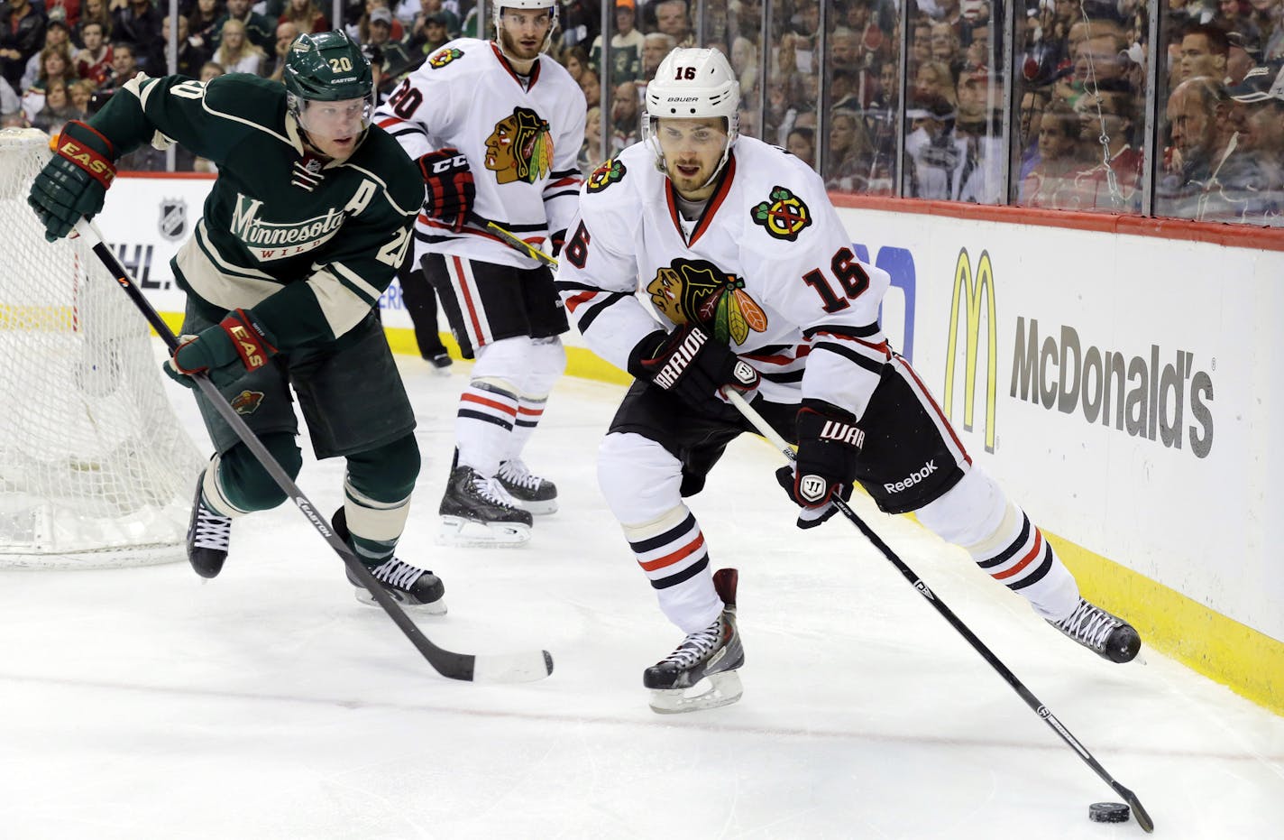 Chicago Blackhawks center Marcus Kruger (16) controls the puck in front of Minnesota Wild defenseman Ryan Suter (20) during the second period of Game 3 of an NHL hockey second-round playoff series in St. Paul, Minn., Tuesday, May 6, 2014. (AP Photo/Ann Heisenfelt)