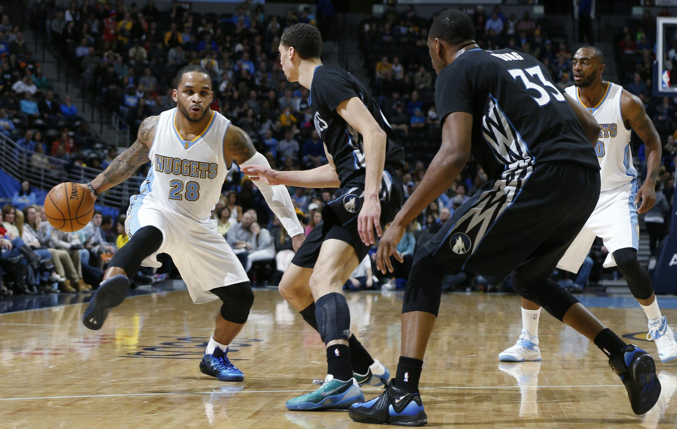 Denver Nuggets guard Jameer Nelson is defended by Minnesota Timberwolves guard Zach LaVine, center, and forward Thaddeus Young during the fourth quarter of an NBA basketball game Saturday, Jan. 17, 2015, in Denver. The Timberwolves won 113-105. (AP Photo/David Zalubowski)