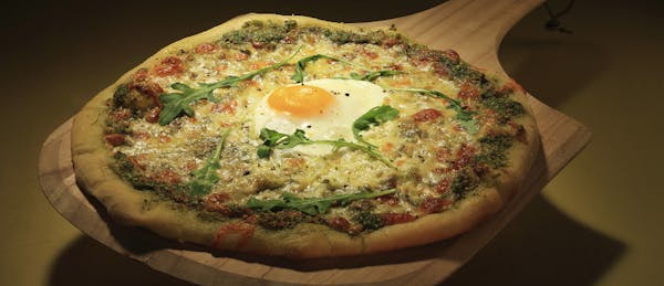 A breakfast-style pizza with a fried egg on top brings out the kid in us. (Chris Walker/Chicago Tribune/MCT) ORG XMIT: 1137709