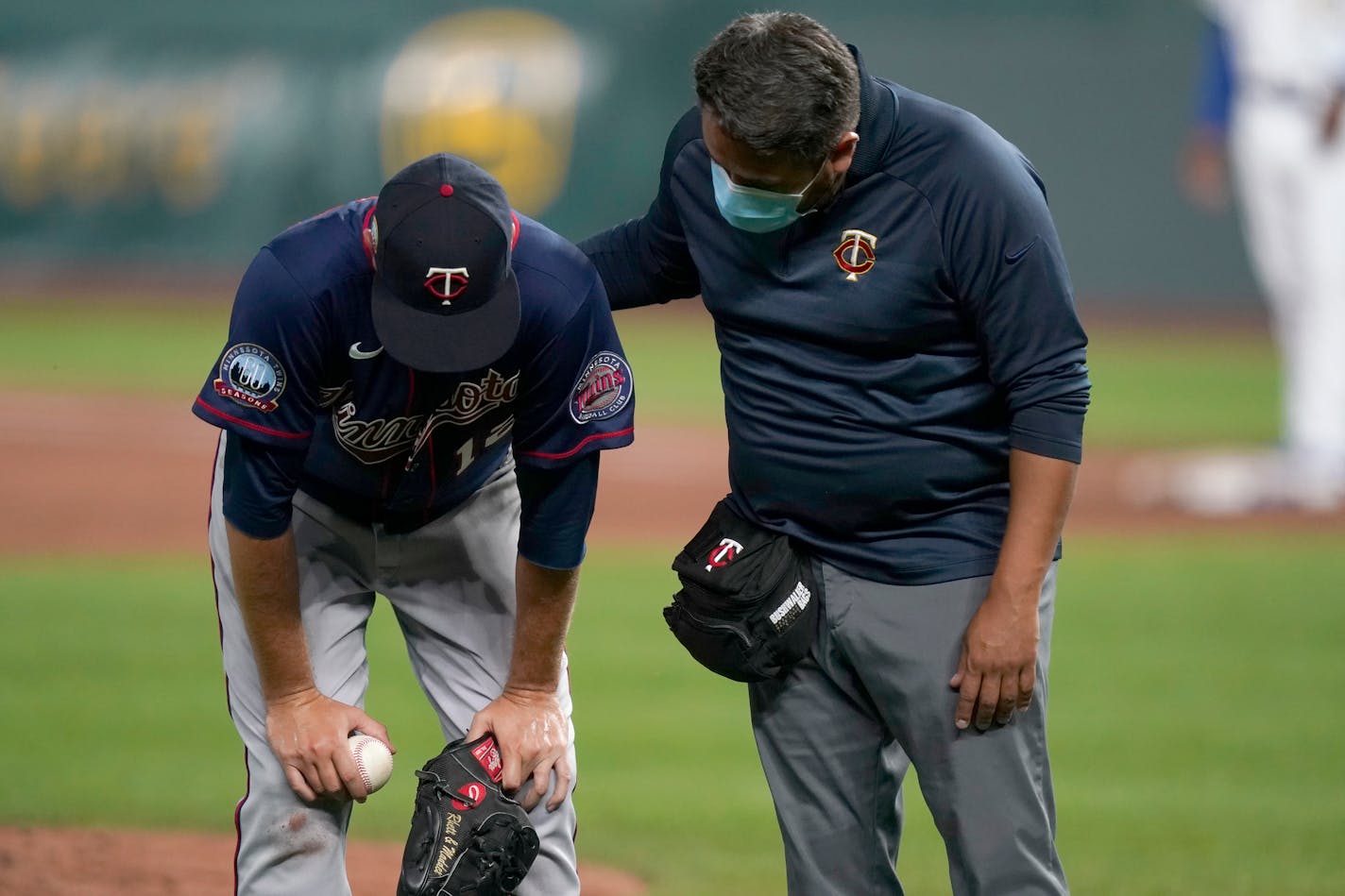 Twins starting pitcher Jake Odorizzi, left, is checked on by a trainer after getting hit by a ball during the fourth inning