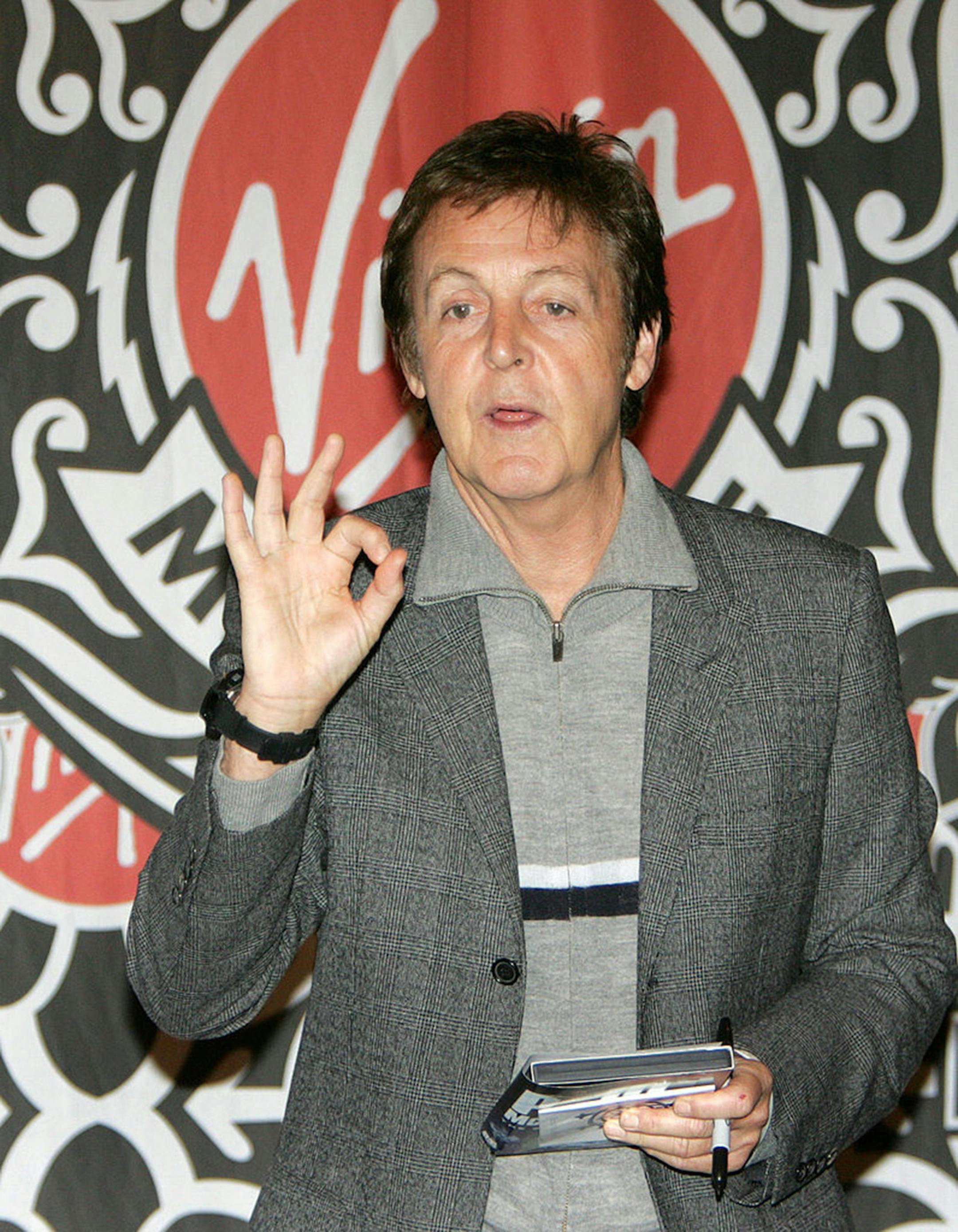 Former Beatle Sir Paul McCartney flashes an OK sign to photographers at the Virgin Megastore 13 November 2006 in New York. McCartney was on hand to sign autographs in celebration of the release of his new concert DVD and classical CD. (DON EMMERT/AFP/Getty Images/TNS) *FOR USE WITH THIS IMAGE ONLY*