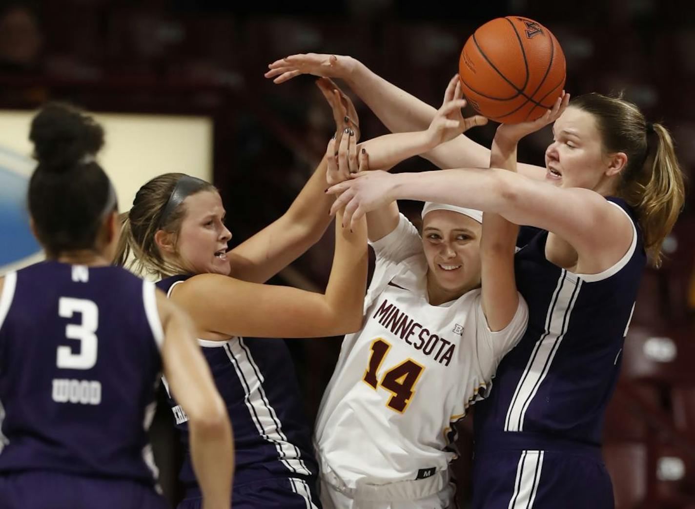 Gophers Sara Scalia (14) ran into the defense of Wildcats Abi Scheid (44) and Abbie Wolf (21).