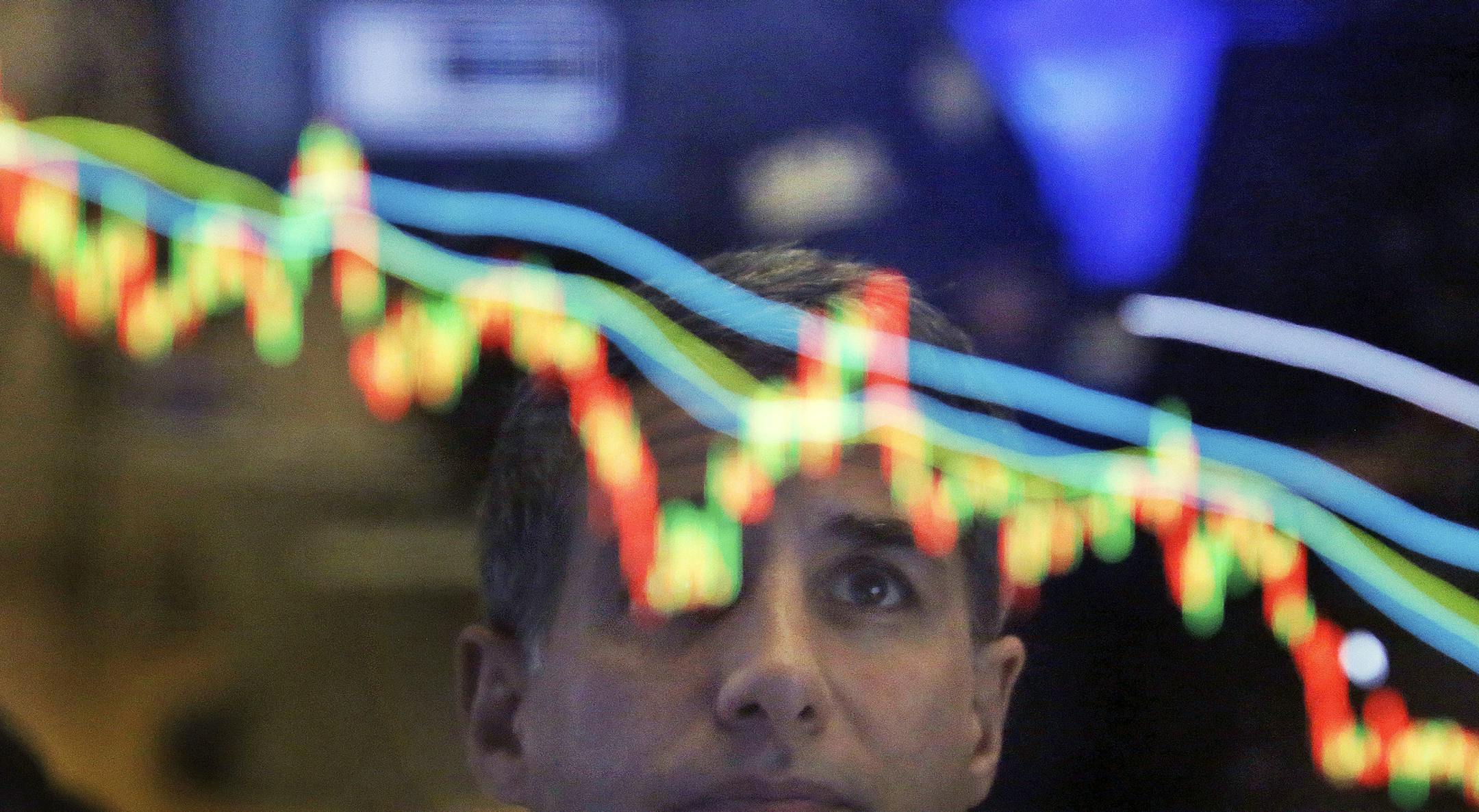 Specialist Anthony Rinaldi is reflected in a screen at his post on the floor of the New York Stock Exchange, Wednesday, April 19, 2017. U.S. stocks are rebounding Wednesday morning as strong results from Morgan Stanley and rising bond yields send banks and other financial companies higher. (AP Photo/Richard Drew)