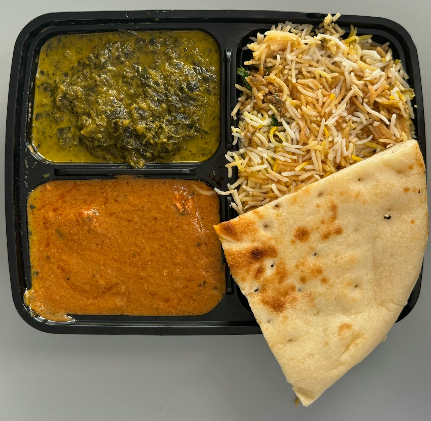 A chicken biryani plate with palak paneer and tikka masala from Spice Shack in downtown Minneapolis.