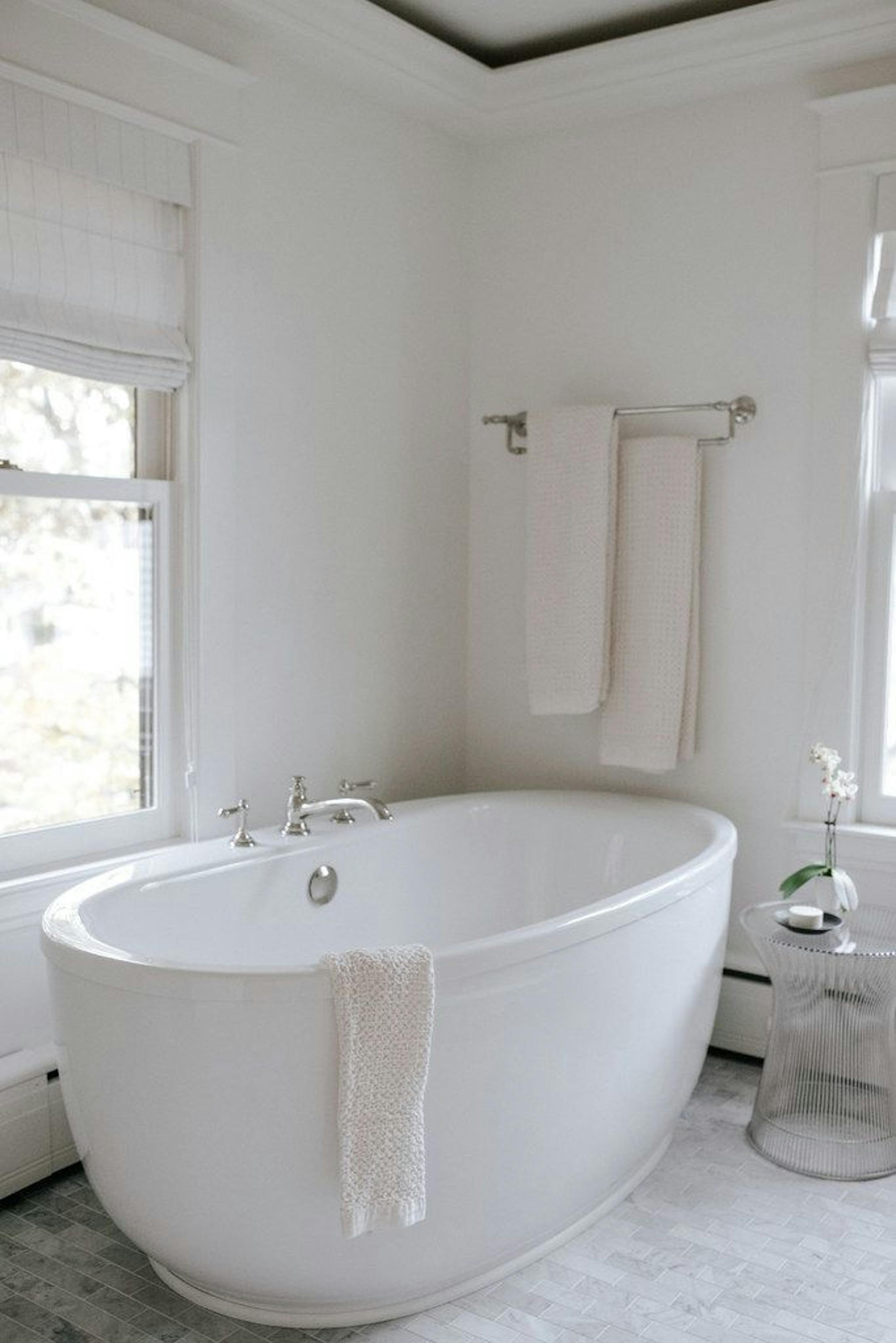 A new soaking tub and modern side table look at home with the traditional architecture of the house.