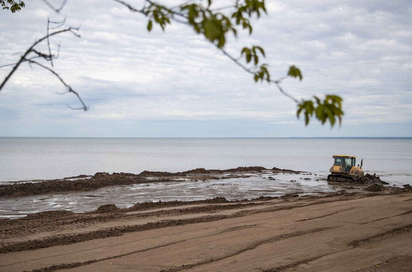 A bulldozer pushed dirt along Park Point beach.