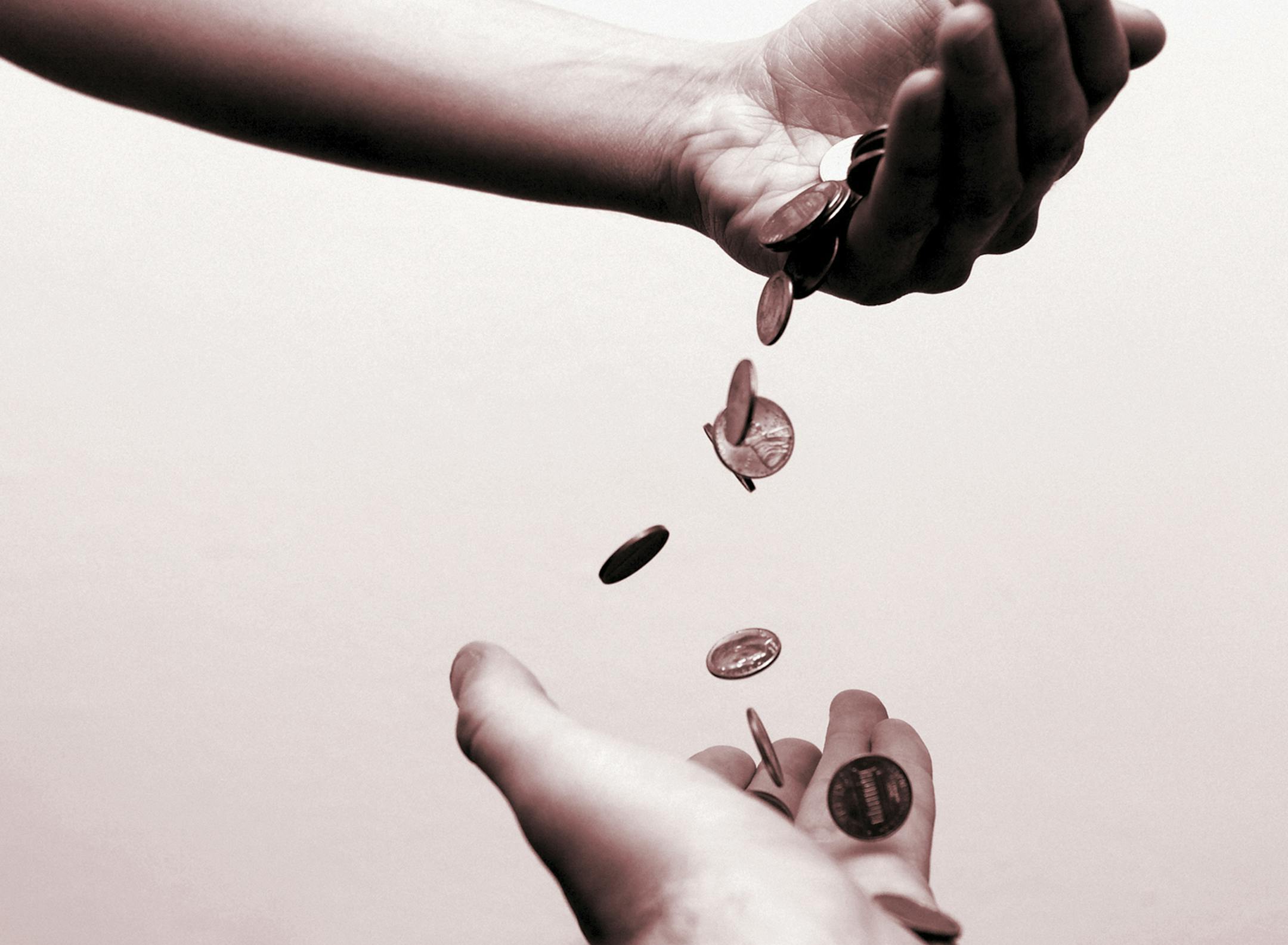 Money falling from one hand to another.