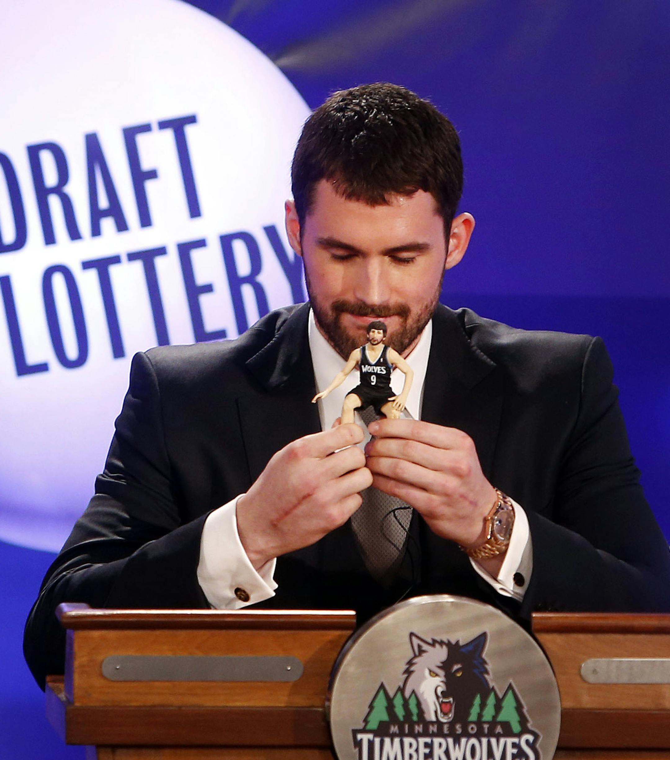 Minnesota Timberwolves' Kevin Love, left, holds a Ricky Rubio bobble head doll he brought for good luck as Portland Trailblazers' Damian Lillard watches during the NBA basketball draft lottery, Tuesday, May 21, 2013 in New York. (AP Photo/Jason DeCrow)