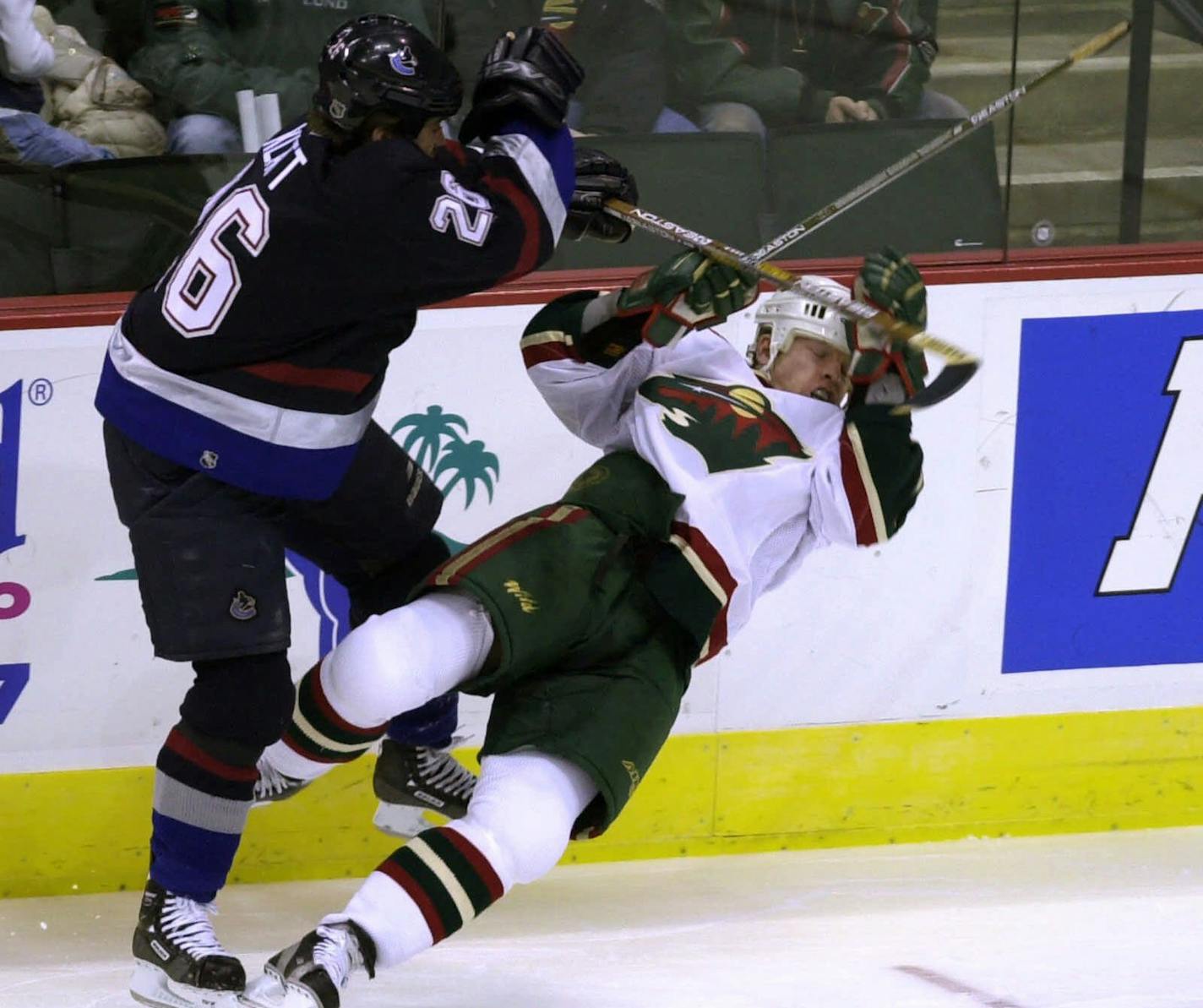 Minnesota Wild's Cam Stewart, right, is checked by Vancouver Canucks' Trent Klatt, left, in the first period in St. Paul, Minn., Monday, Feb. 26, 2001. (AP Photo/Tom Olmscheid)