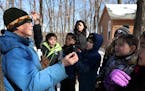 Volunteer Fern Albertson explained how to tap a maple tree to extract sap to a group of students from the Saint John School of Little Canada.