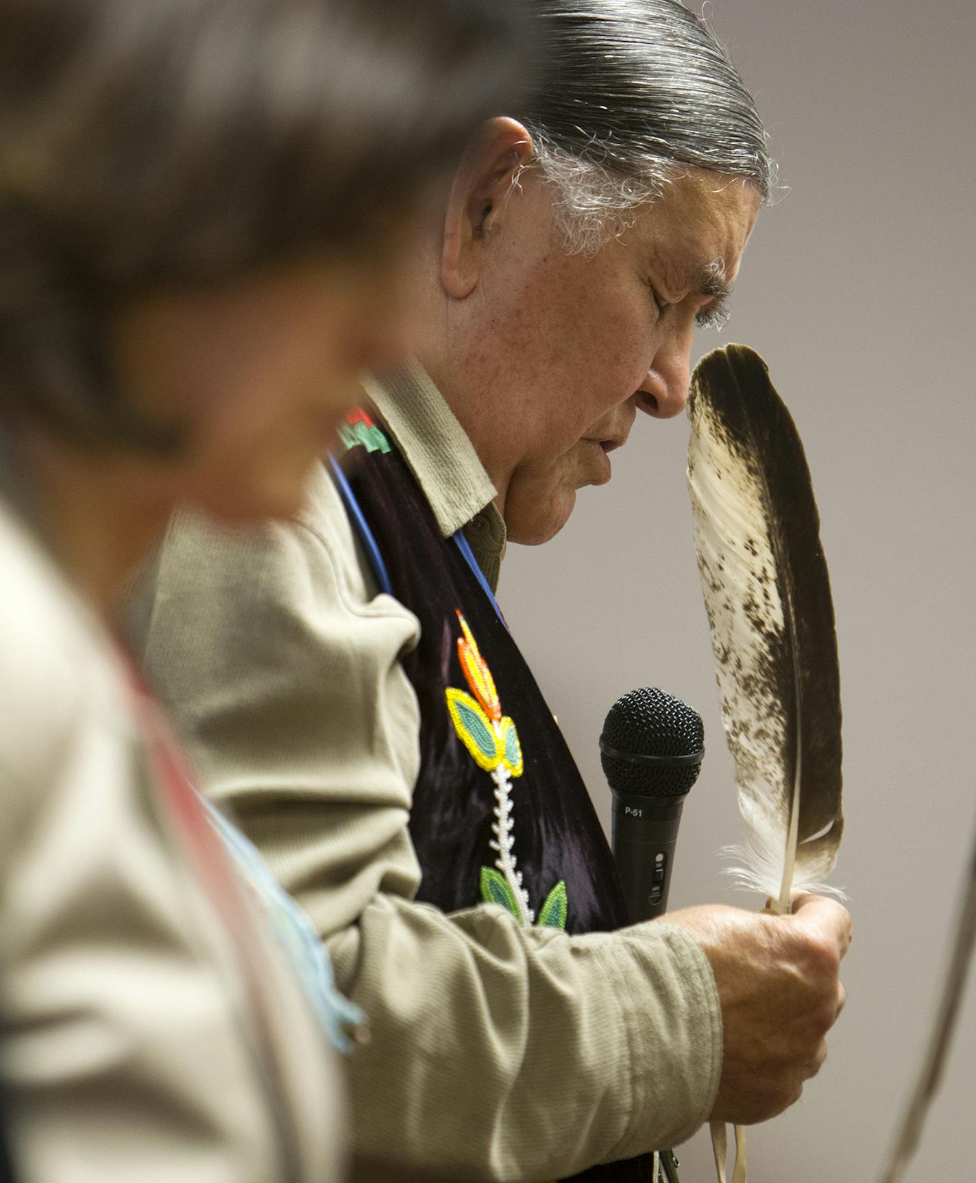 Thunder Before the Storm (Clyde Bellecourt) holds a condor feather while praying before the Minneapolis City Council unanimously voted to call what has been known as Columbus Day "Indigenous People's Day" April 25, 2014. (Courtney Perry/Special to the Tribune)