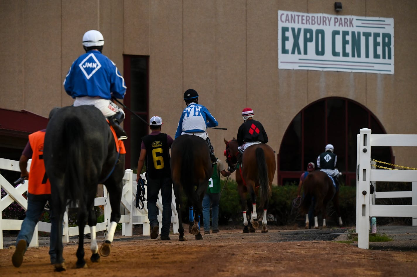 Jockeys and their horses are led from the paddocks to the track before a race Wednesday, Aug. 16, 2023 at Canterbury Park in Shakopee, Minn. ] AARON LAVINSKY • aaron.lavinsky@startribune.com