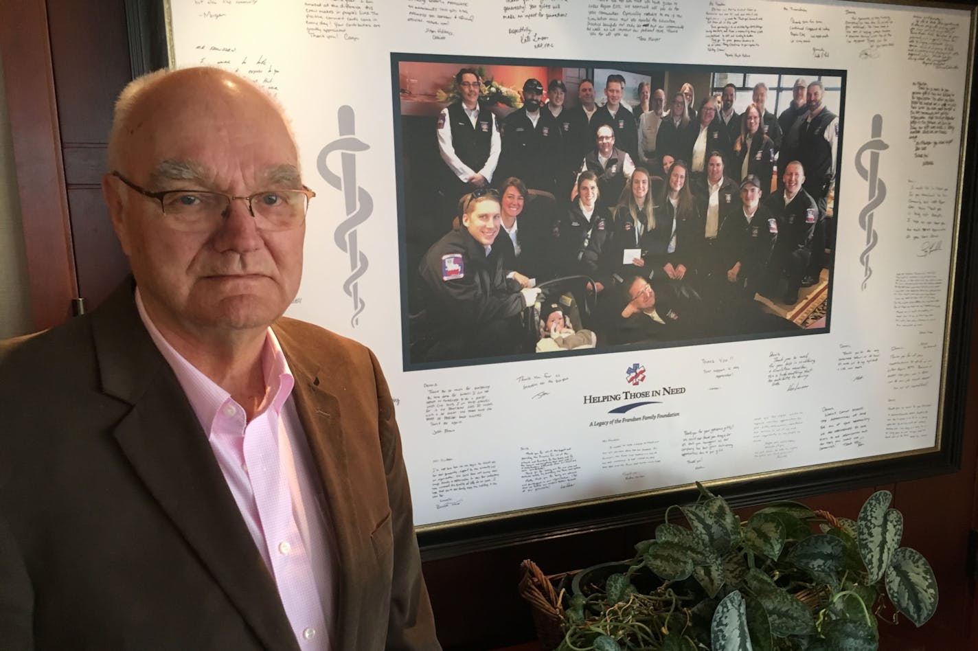 Business owner Dennis Frandsen, pictured at his North Branch headquarters with a signed picture by some of the 70 Lakes Region Emergency Services team that serves several counties in east-central Minnesota and western Wisconsin. Frandsen, 85, founder and chairman of manufacturing-and-banking Frandsen Corp., has donated several million to the life-saving nonprofit for equipment and buildings over the last few years. Frandsen and his wife plan to donate their majority ownership in Fransden Corp to