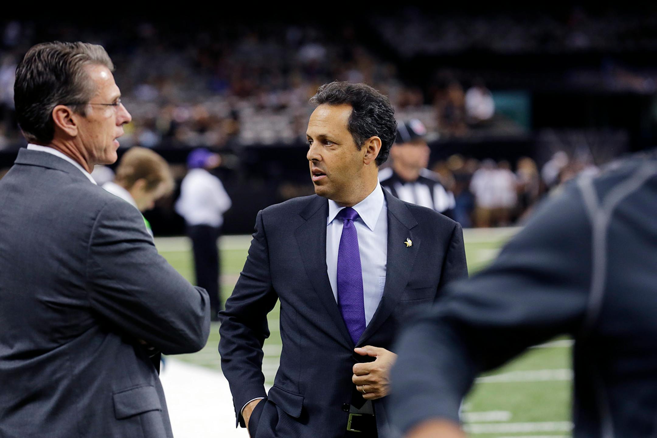 Minnesota Vikings co-owner Mark Wilf, right, and general manager Rick Spielman walk on the field before an NFL football game against the New Orleans Saints in New Orleans, Sunday, Sept. 21, 2014. (AP Photo/Bill Haber)