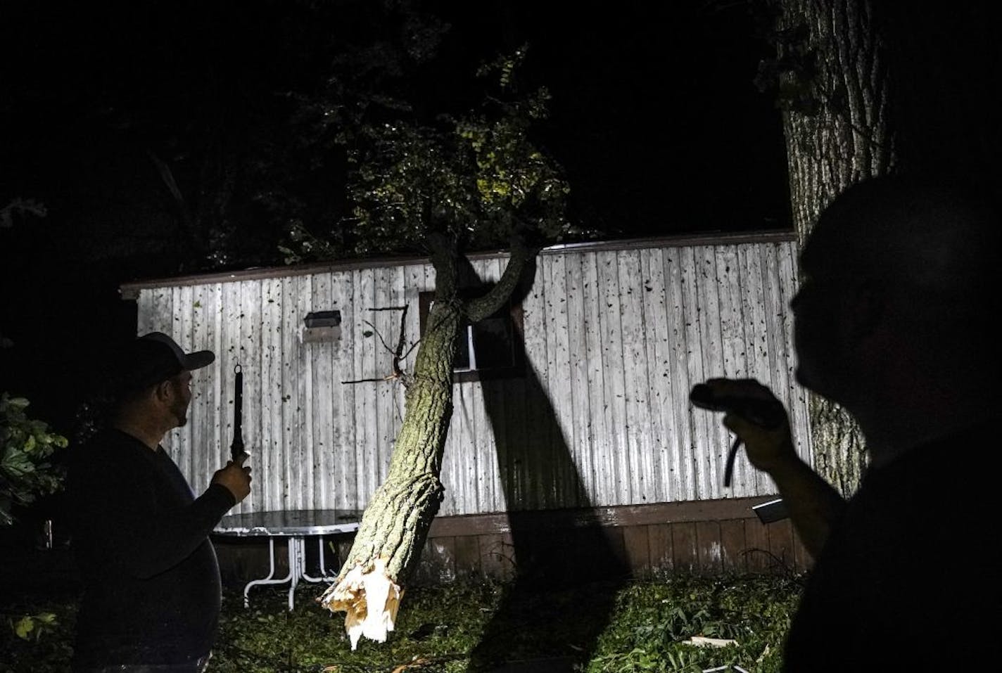 Lem Switzer, right, and Skyler Hansen surveyed the damage around Switzer's home following a reported tornado Thursday night in Northfield near Dundas.