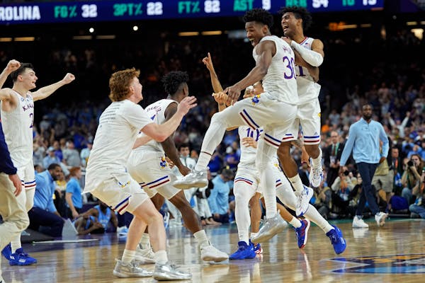 Kansas guard Ochai Agbaji celebrates with teammates after their win against North Carolina in a college basketball game in the finals of the Men's Fin
