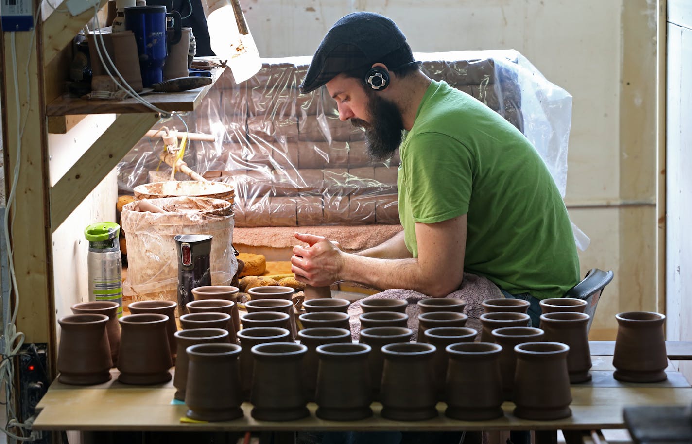 Deneen Pottery employee Jonathan Conrad hand formed mugs on a pottery wheel on 4/30/14. Profile on Deneen Pottery, a small St. Paul company that makes custom stoneware and coffee mugs the old-fashioned way, by tossing a lump of clay on a potter's wheel. The company is growing by leaps and bounds, doubling its number of employees to more than 50 over the last couple of years. They even have a dog wandering the factory and shop.] Bruce Bisping/Star Tribune bbisping@stribune Jonathan Conrad/source