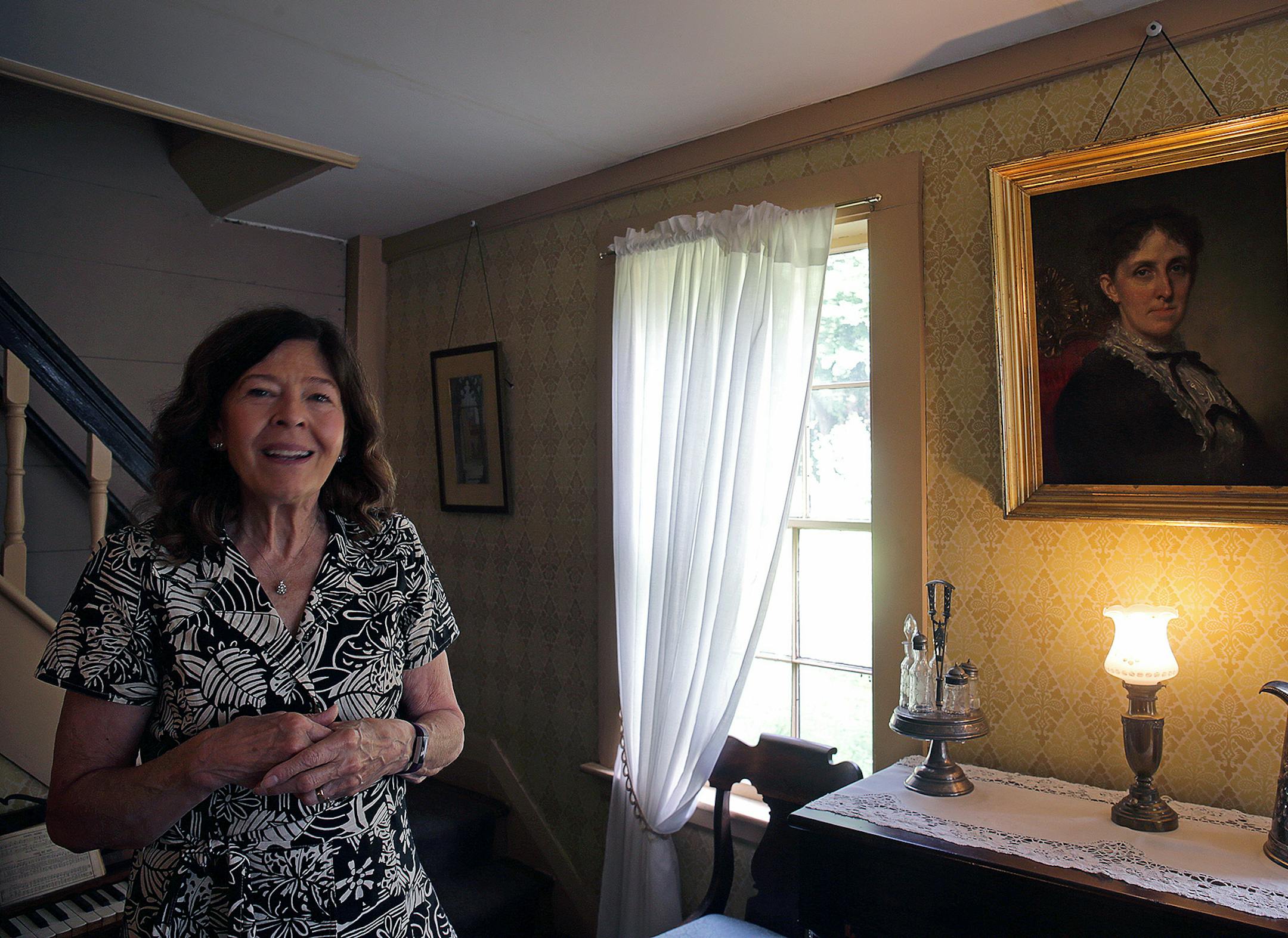 Jan Turnquist, executive director for Louisa May Alcott's Orchard House in Concord, Mass., poses next to a portrait of Louisa May Alcott done by George Healey, a famous portrait painter, on Sep. 11, 2018. (Barry Chin/The Boston Globe/Getty Images/TNS) ORG XMIT: 1561791