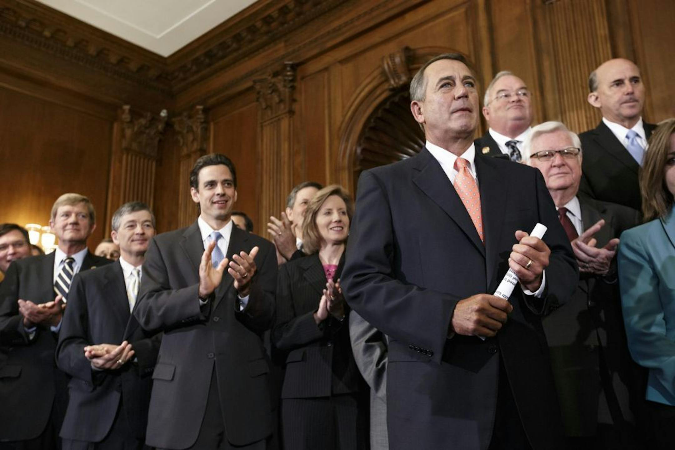Speaker of the House John Boehner, R-Ohio, right, is cheered as Republican members of the House of Representatives rally after passing a bill that would prevent a government shutdown while crippling the new health care law.