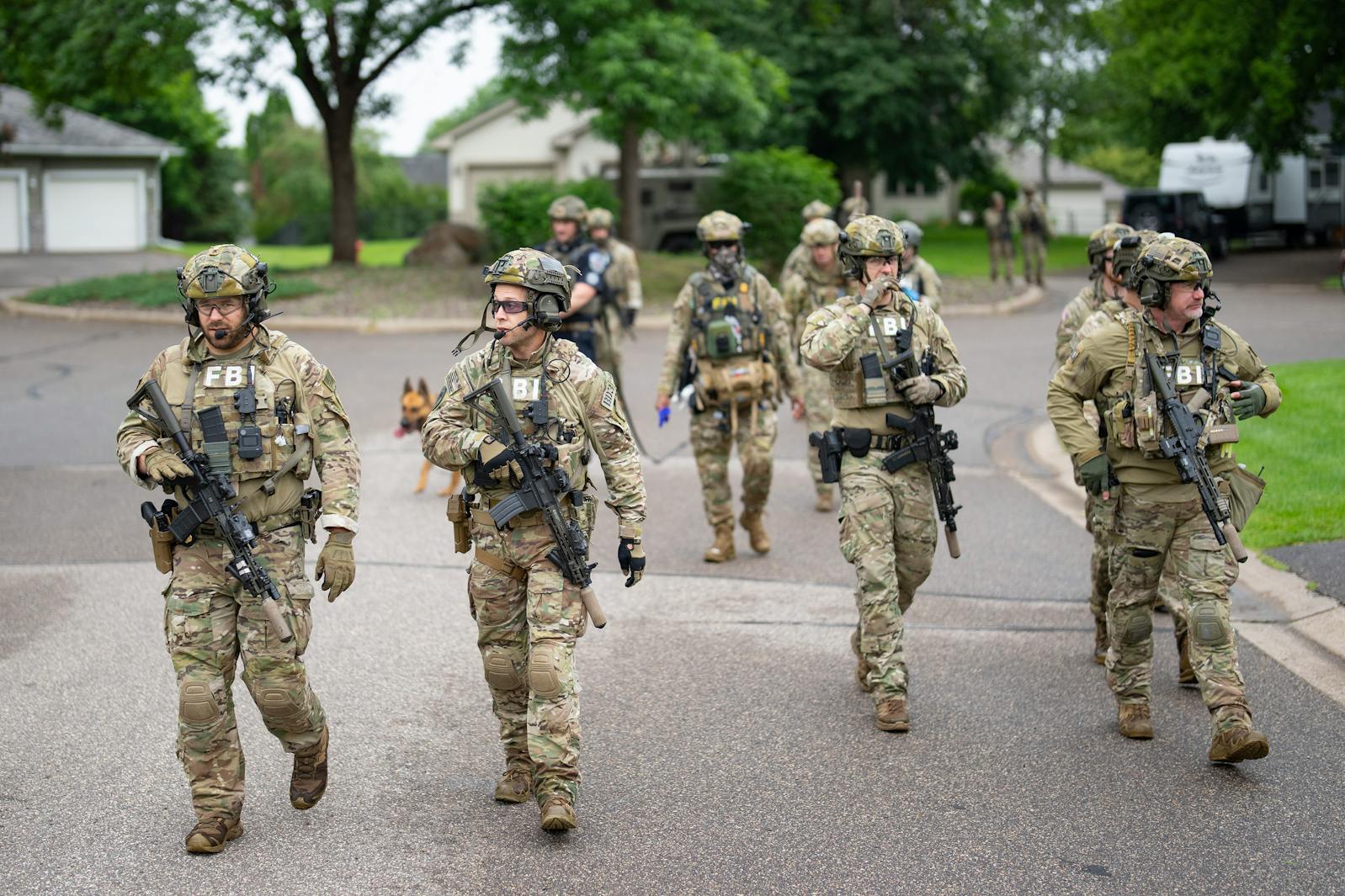 Armed FBI agents search for an active shooter by sweeping a neighborhood adjacent to the home of Minnesota DFL State Representative Melissa Hortman in Brooklyn Park.