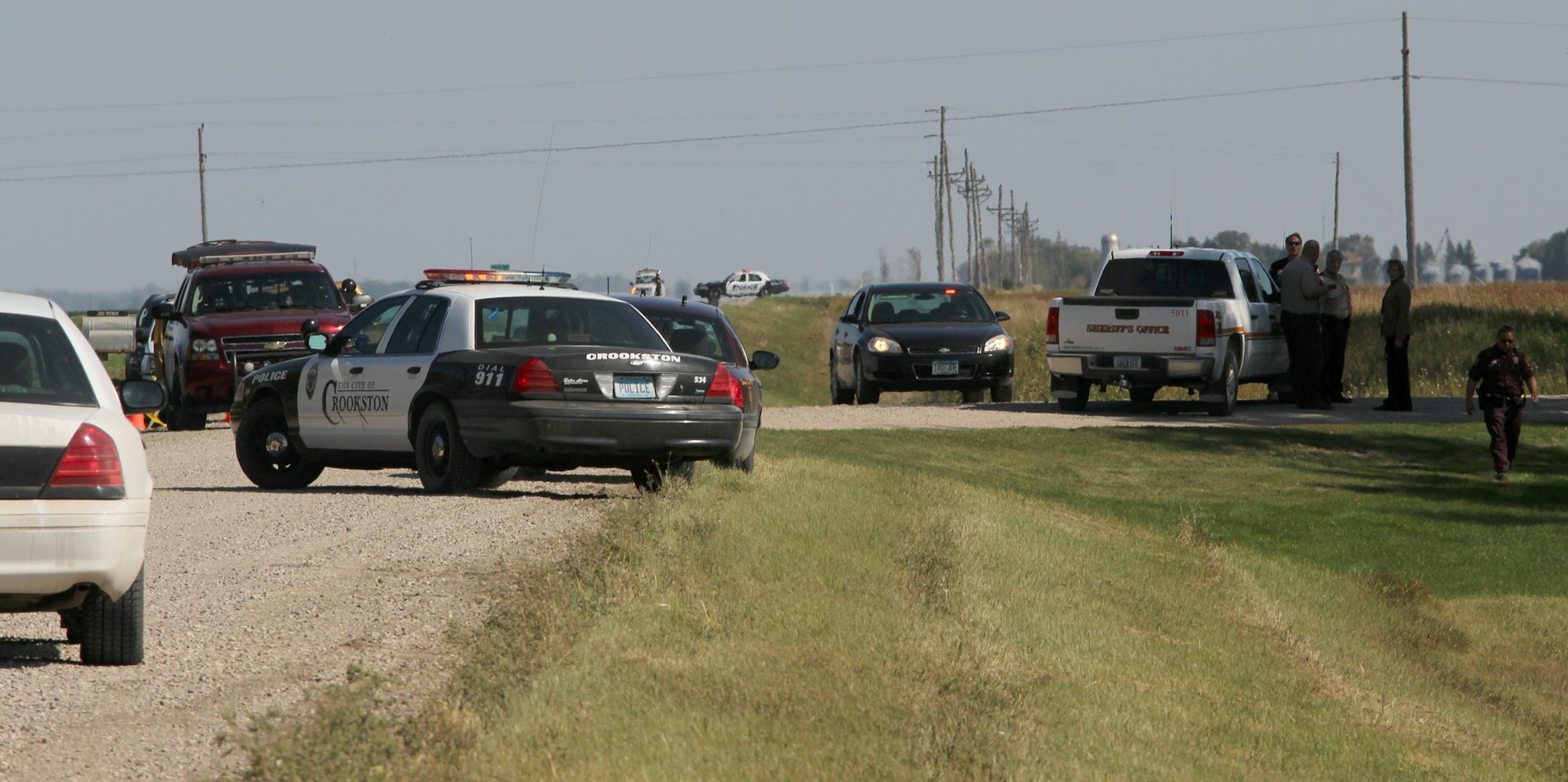 Multiple law enforcement vehicles and law enforcement officers converge on Perry Farms south of Crookston, Minn., Thursday, Sept. 18, 2014. Authorities say a northwestern Minnesota sheriff's deputy and a suspect are wounded after an officer-involved shooting. The Minnesota Bureau of Criminal Apprehension says the shooting happened Thursday in rural Crookston in Polk County. A Polk County sheriff's deputy and the suspect are being treated for non-life-threatening injuries. (AP Photo/The Daily Tim