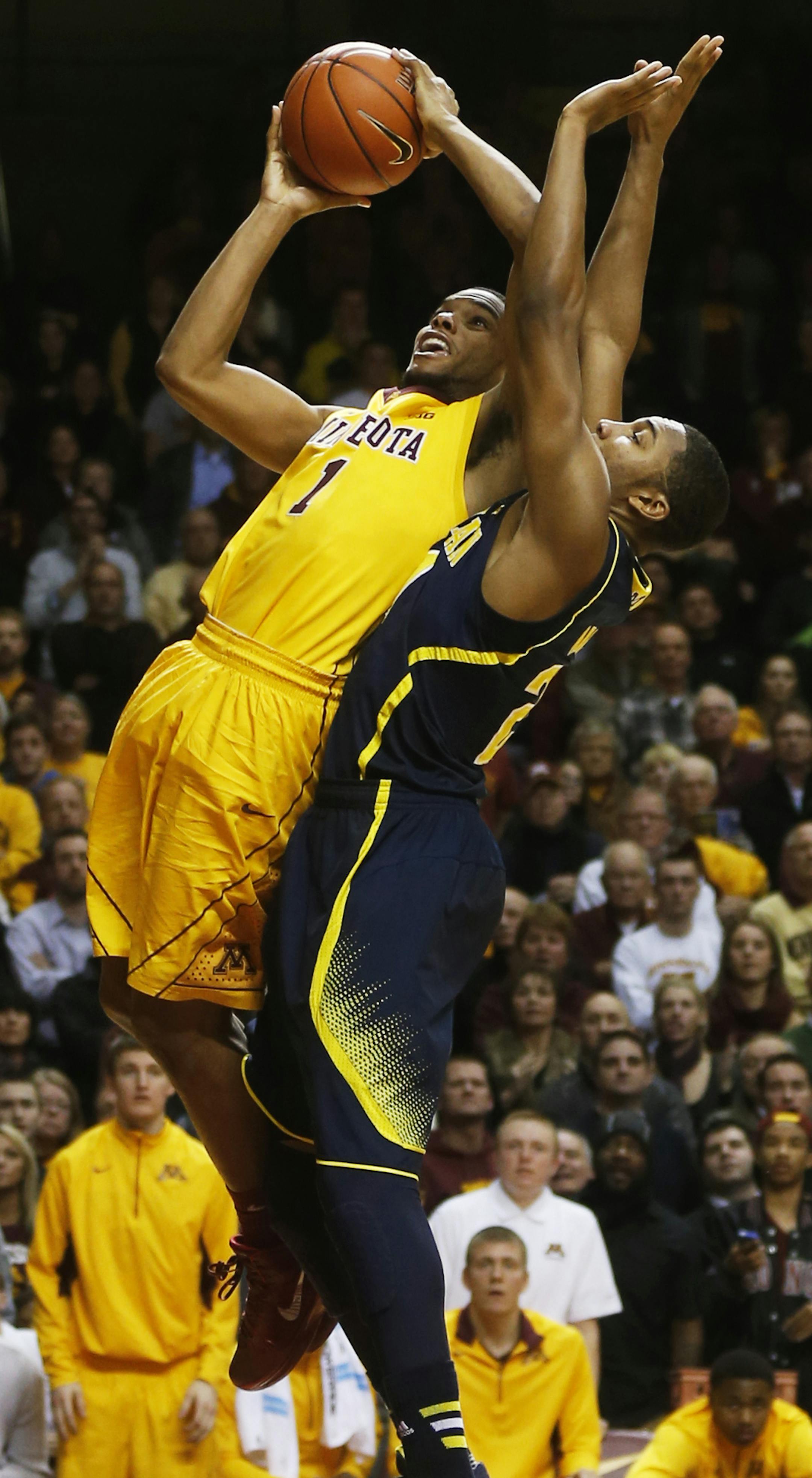 Gophers guard Andre Hollins drove to the basket but missed a key layup late in the game as Michigan&#x2019;s Derrick Walton Jr. defended during the Wolverines&#x2019; 63-60 victory in the Big Ten opener for both teams in Williams Arena.