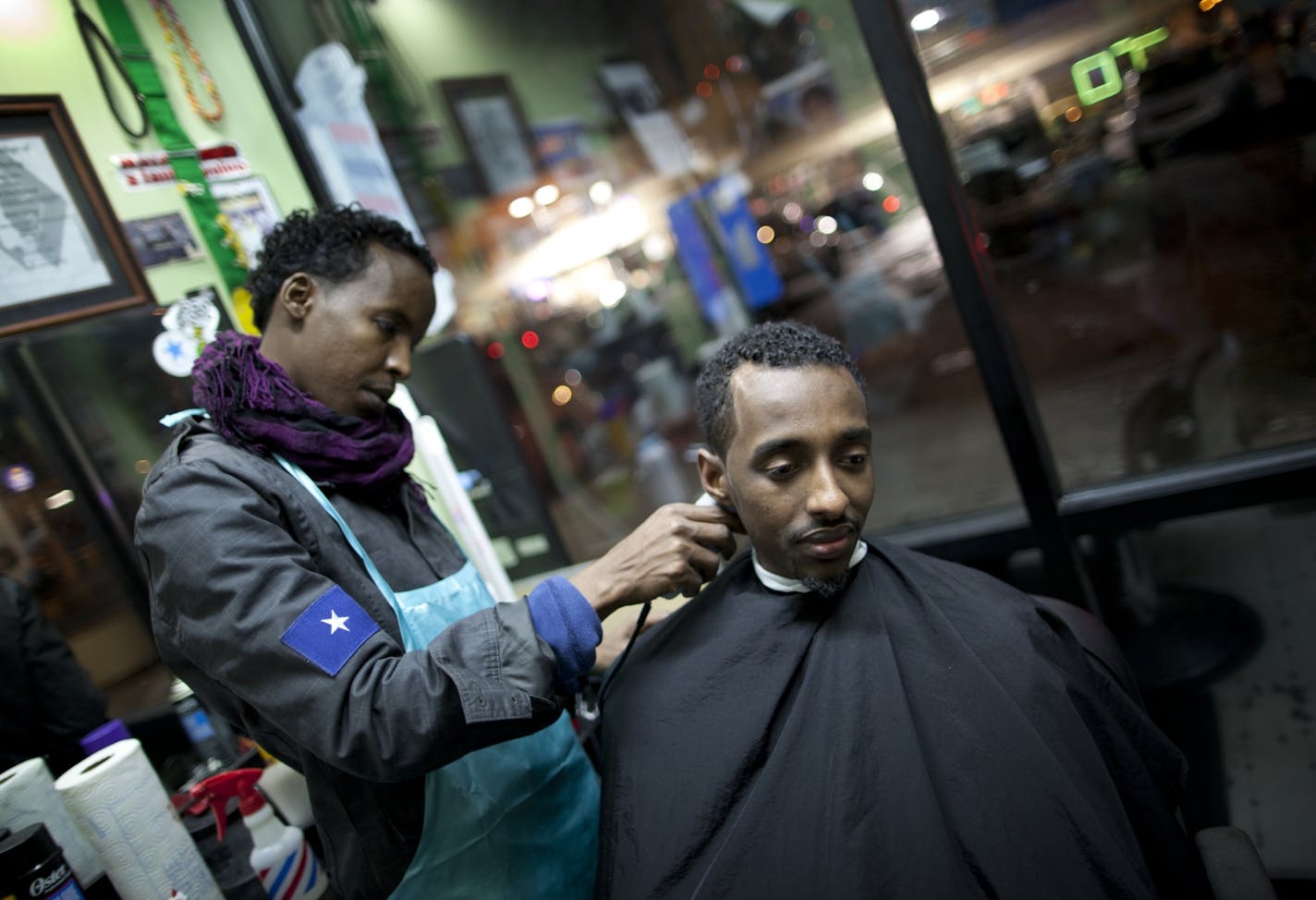 Barber Happy Khalif and his customer Abdi Bombolo at Happy Khalif's Barber Shop at Karmel Square in Minneapolis, Minn. on January 3, 2012.