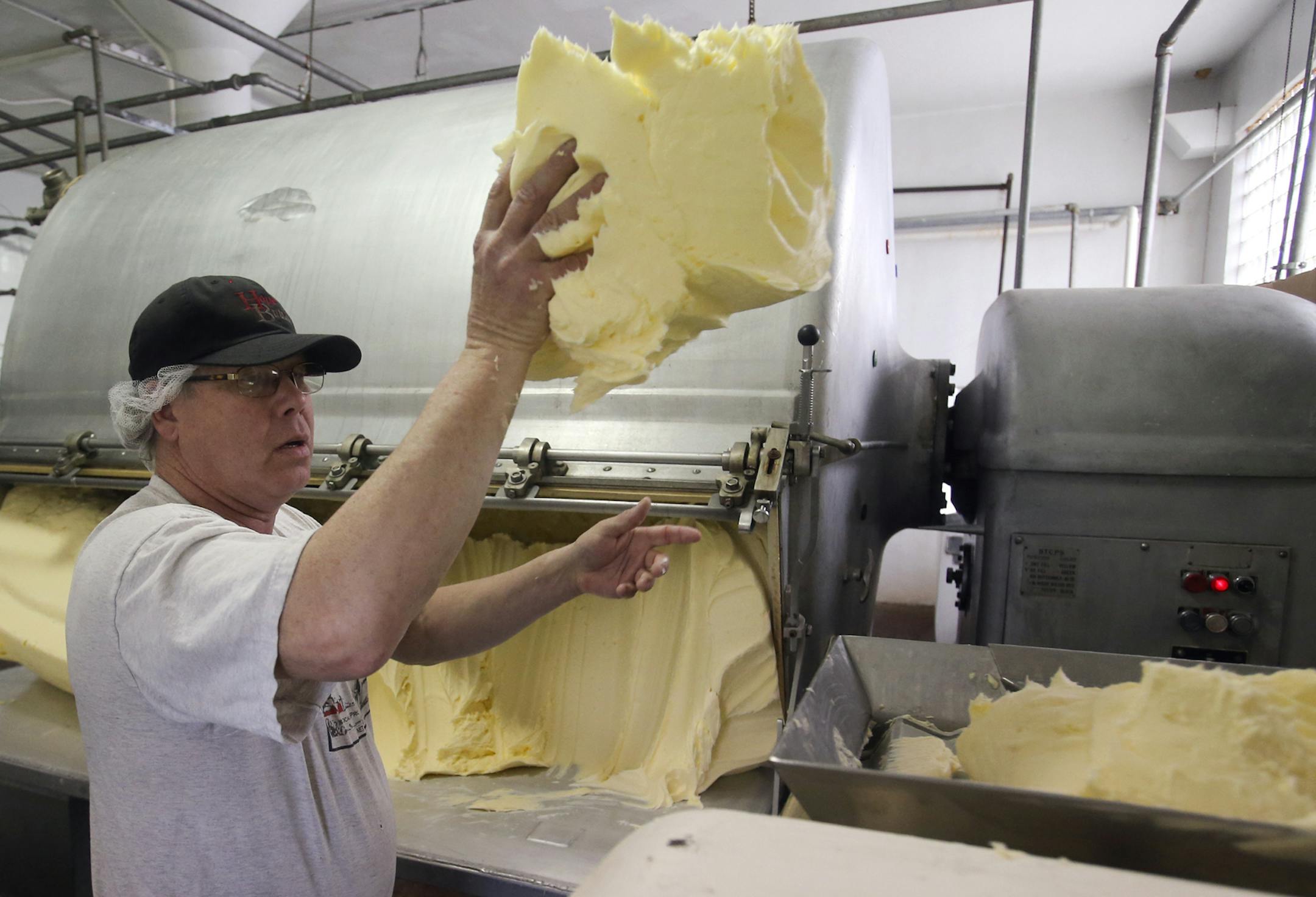 Hope Creamery manager Jay Logan tossed a chunk of freshly churned butter into the butter wrapping machine Thursday in Hope, Minn. The creamery, which churns more than 300,000 pounds of butter a year, has found success selling to Twin Cities eateries and grocery stores.