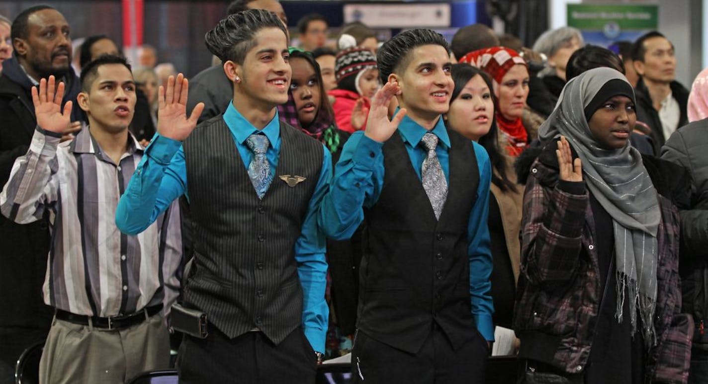 Brothers Avnish Kumar, 18, center left, and Abhay Kumar, 15, natives of India, joined 100 others in being sworn in as U.S. citizens Saturday during a ceremony at the Mall of America. "I love America," Avnish Kumar said.