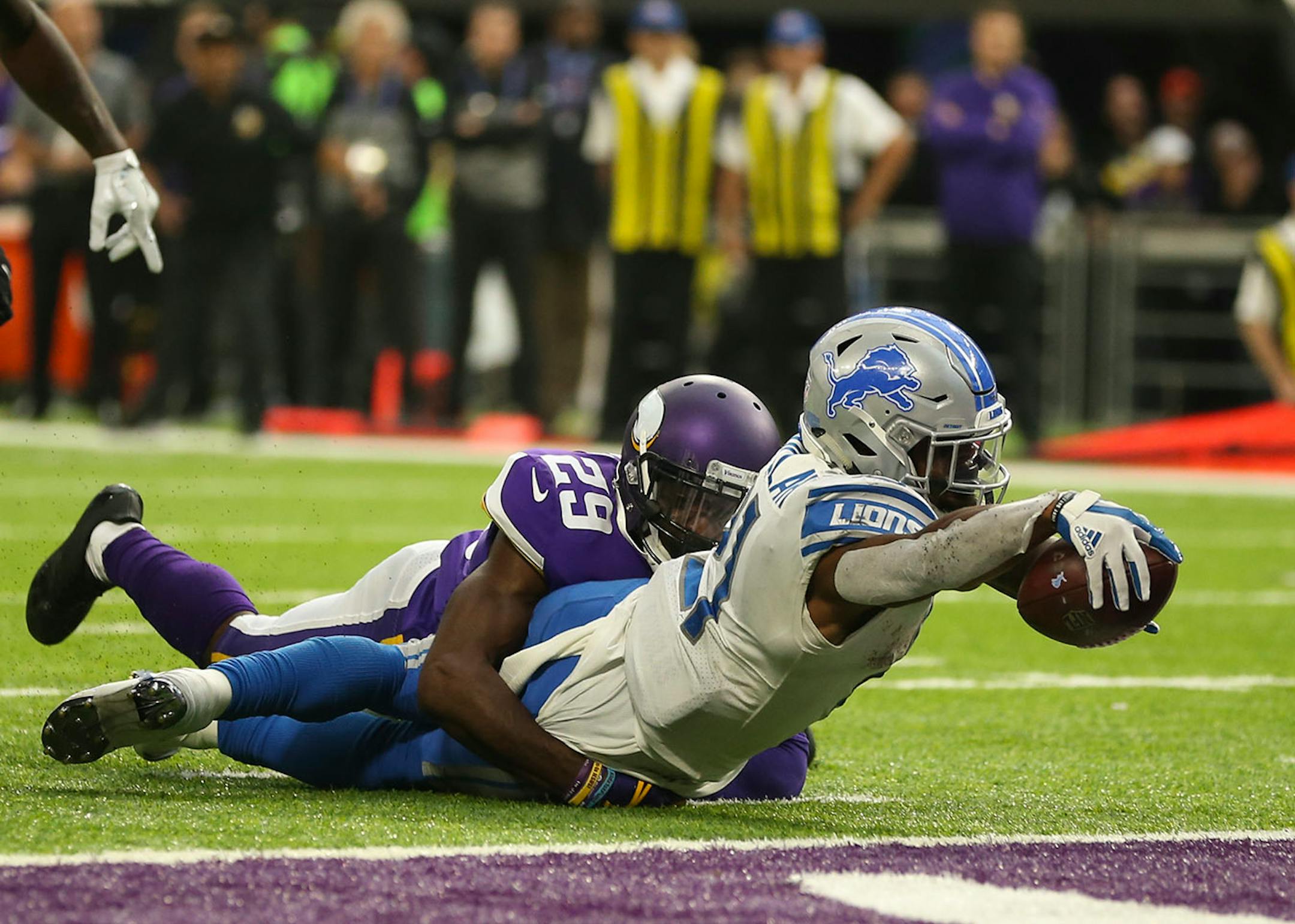 Detroit Lions running back Ameer Abdullah (21) scored from the two yard line as he was nearly stopped by Minnesota Vikings cornerback Xavier Rhodes (29) in the third quarter. Officials initially ruled him down by contact, but a Detroit challenge gave the Lions what proved to be the winning touchdown.