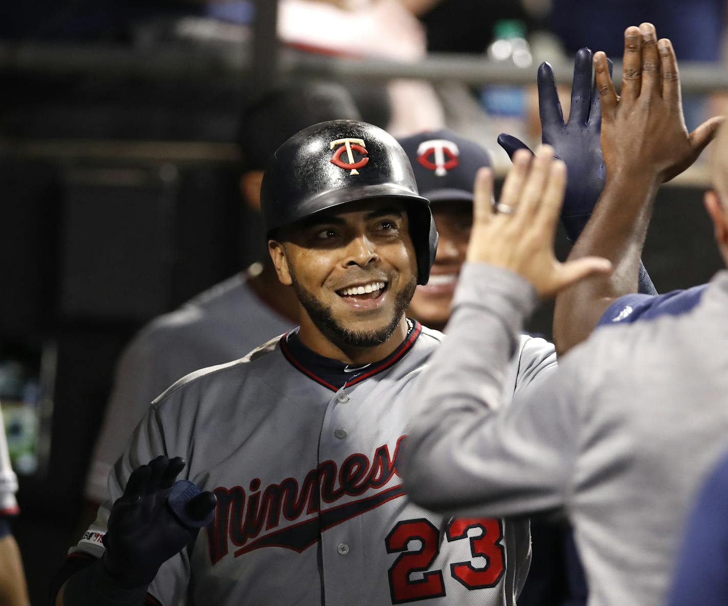 Minnesota Twins' Nelson Cruz celebrates with teammates in the dugout after hitting a solo home run during seventh inning of a baseball game against the Chicago White Sox, Friday, July 26, 2019, in Chicago. (AP Photo/Jeff Haynes)