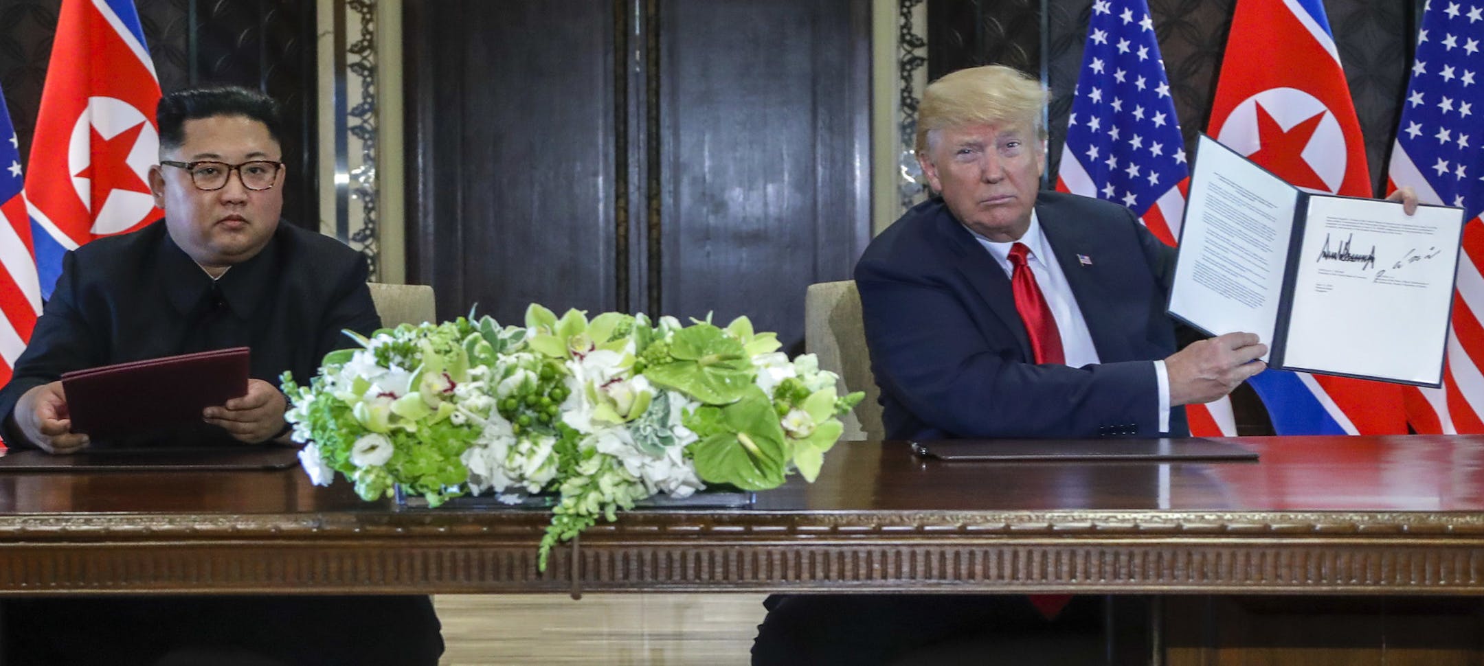 U.S. President Donald Trump holds up the document that he and North Korea leader Kim Jong Un just signed at the Capella resort on Sentosa Island Tuesday, June 12, 2018 in Singapore. The most tangible outcome of the summit between President Donald Trump and North Korean leader Kim Jong Un seems to be a commitment to recover the remains of U.S. military personnel missing in action and presumed dead from the Korean War. In a joint statement signed by the leaders Tuesday, the countries committed to