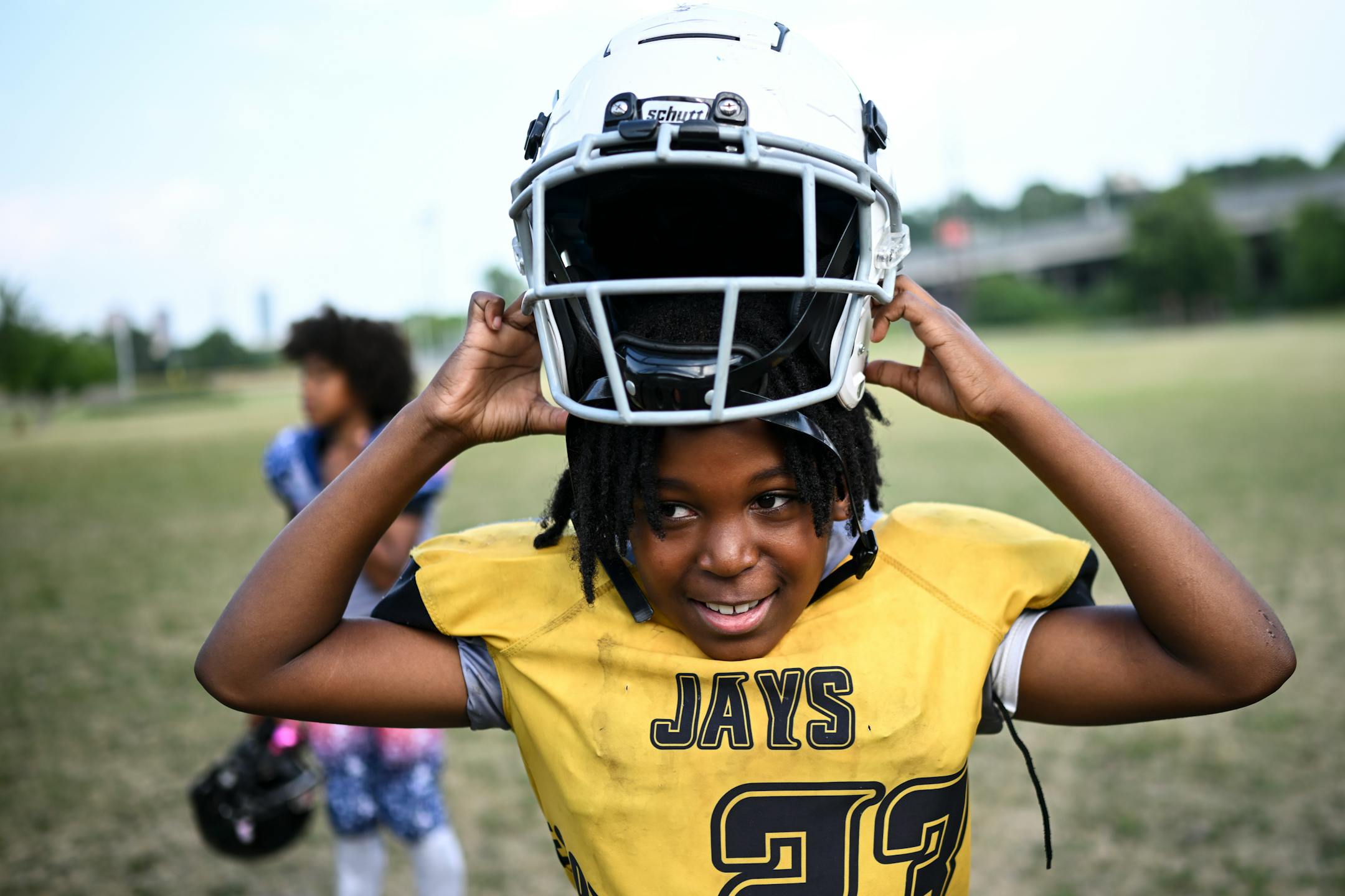 Kiiantes Todd, 11, puts on his helmet before practice Monday, July 24, 2023 at Bryn Mawr Meadows Park in Minneapolis. "They started shooting and we had to run around the corner and hide," said Todd, who witnessed the shooting three years ago. "I was super scared." The Minnesota Jays youth football team, of North Minneapolis, practiced before an upcoming game in St. Louis. The team's recent regional championship comes about three years after their practice was interrupted by gunfire.