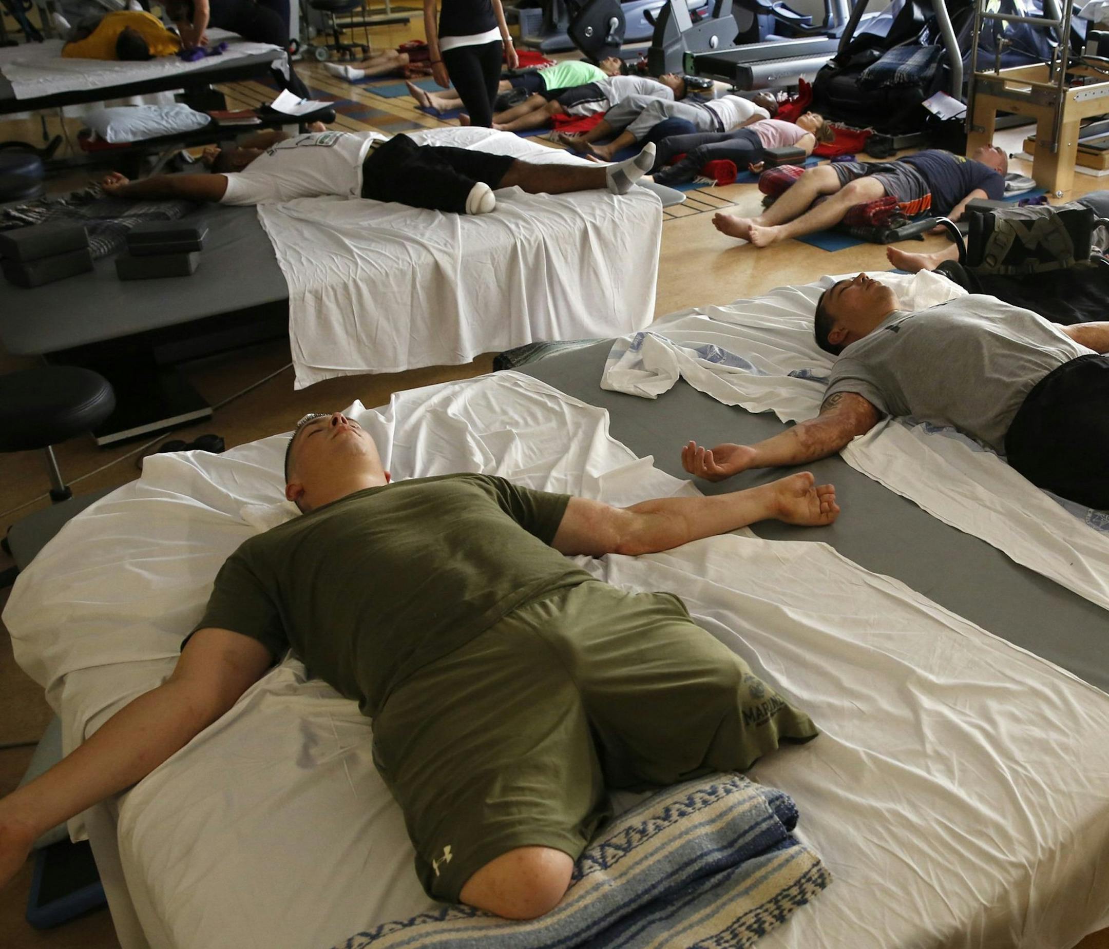 Double-amputees U.S. Marine PFC Isaac Blunt, left, and U.S. Army Sgt 1st Class Chris Montera lie still during a yoga class at the Naval Medical Center in San Diego, California, on June 10, 2013. Both were gravely wounded in Afghanistan. Other veterans with PTSD or traumatic brain injuries are on the floor for the one-hour class, designed to calm the mind, increase flexibility and improve physical strength. (Don Bartletti/Los Angeles Times/MCT)