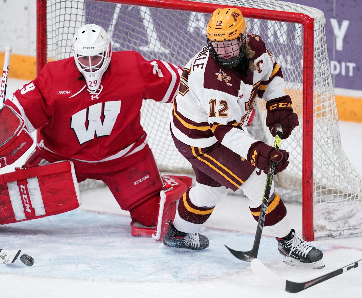 Gophers forward Grace Zumwinkle  tracked a loose puck in front of Wisconsin goaltender Kennedy Blair during a game last month.