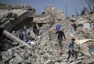 Residents walk amid the rubble of buildings they say were destroyed by airstrikes, in a neighborhood recently retaken by Iraqi security forces from Is
