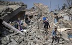 Residents walk amid the rubble of buildings they say were destroyed by airstrikes, in a neighborhood recently retaken by Iraqi security forces from Is