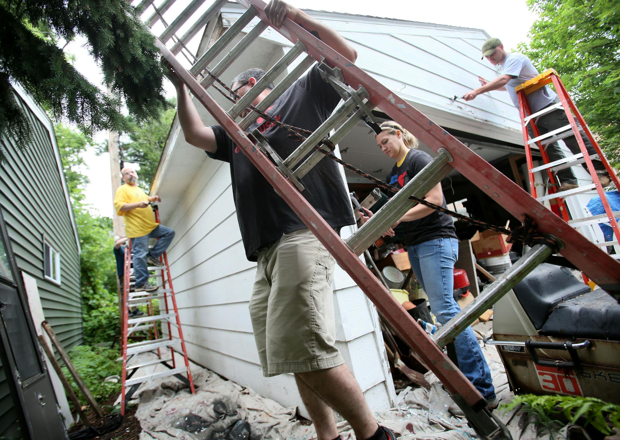 Here, Habitat for Humanity volunteer Ray Bracht, a Navy vet moves a ladder into place. About a dozen Habitat for Humanity volunteers from General Mills and Thrivent Financial for Lutherans and other groups joined forces Thursday, July 16, 2015, in preparing the painting of an elderly couple's home and garage in RIchfield, MN. The husband in the house is an Army and Army reserve vet. Several of the volunteers were veterans as well. US Bank and Valspar also partnered in A Brush with Kindness progr