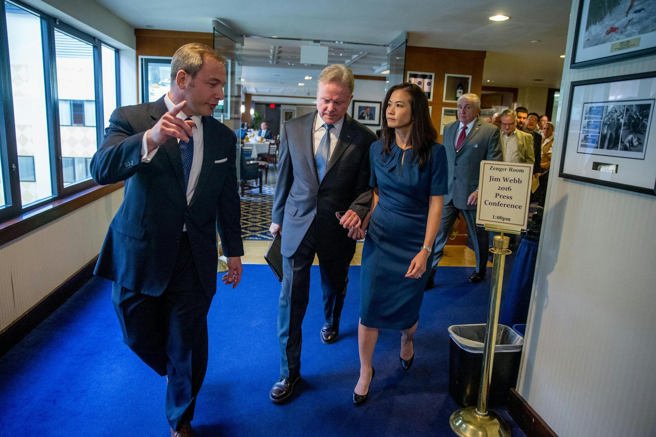 Former Virginia Sen. Jim Webb, accompanied by his wife Hong Le Webb, right, leaves a press conference where he announced he will drop out of the Democratic race for president, Tuesday, Oct. 20, 2015, at the National Press Club in Washington. (AP Photo/Andrew Harnik)
