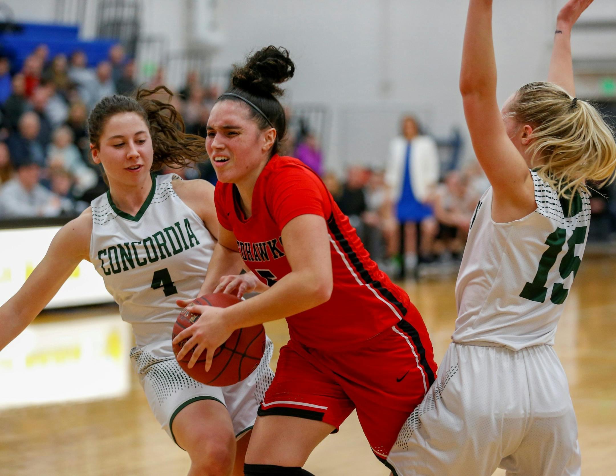 Minnehaha Academy's Mia Curtis splits two Concordia Academy defenders on her way to the basket Friday night. Curtis had 32 points in the Redhawks 72-66 victory over the Beacons. Photo by Jeff Lawler, SportsEngine