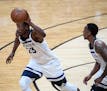 Minnesota Timberwolves guard Jimmy Butler (23) moved the ball down the court in front of fellow guard Jeff Teague (0) in the second quarter Saturday. 