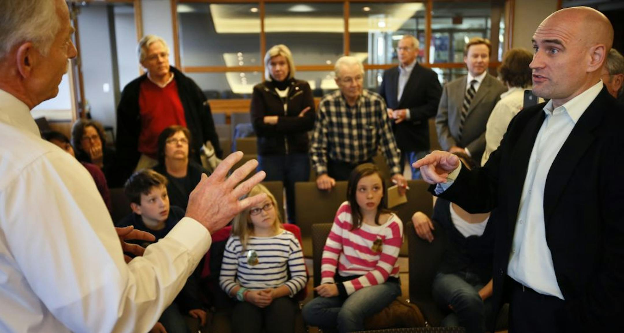 An hour before Monday's MAC meeting started, MAC Executive Director Jeff Hamiel (left) was getting an earfull from Kevin Terrell (right) as the Jones Children of Edina (center) got to watch government in action up close and personal. Their house would be under the new flight paths and came to the meeting with their mother Kim who was speaking in opposition to the new FAA plan.