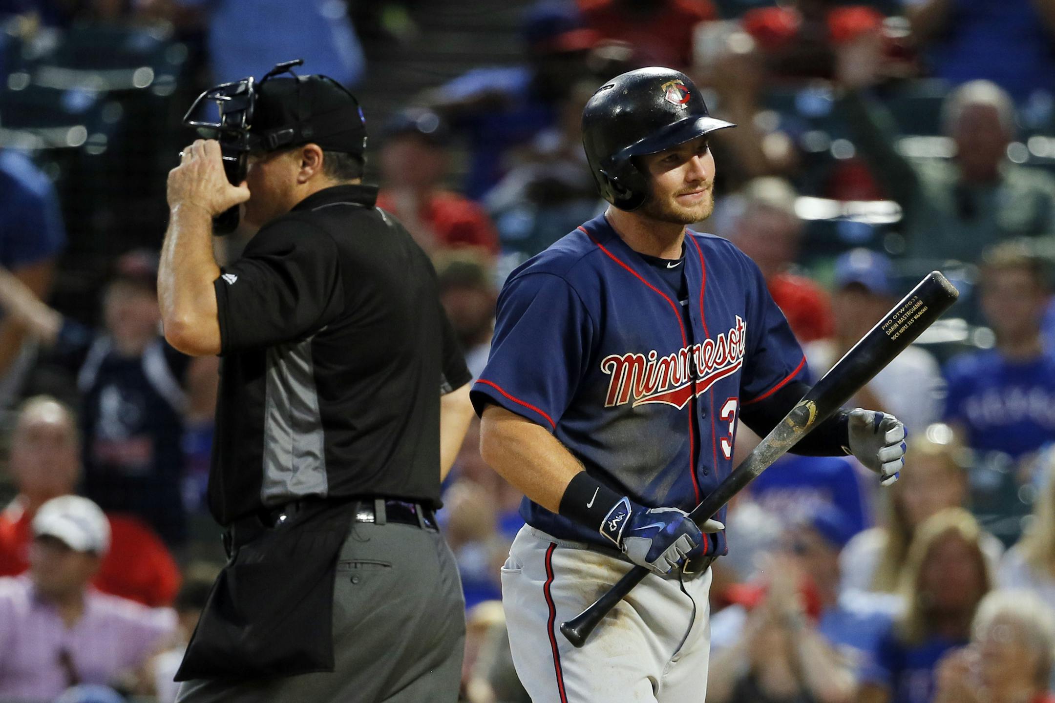 Home plate umpire Tony Randazzo, left, stands by the plate as Minnesota Twins' Robbie Grossman walks back to the dugout after striking out leaving the bases loaded to end the top of the fourth inning of a game against the Texas Rangers.