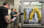 Dunwoody’s robotics and manufacturing faculty and students work on a piece of equipment designed to teach robot-tended machining. Surveys this fall 