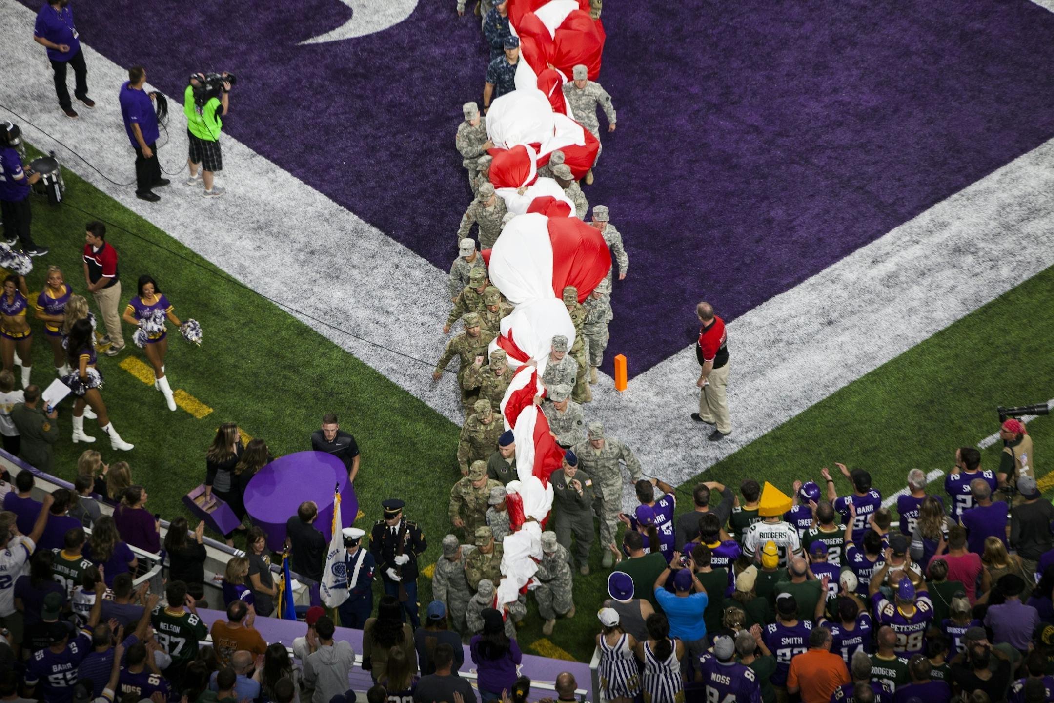Military service members removed a the giant American flag from the field before the game.