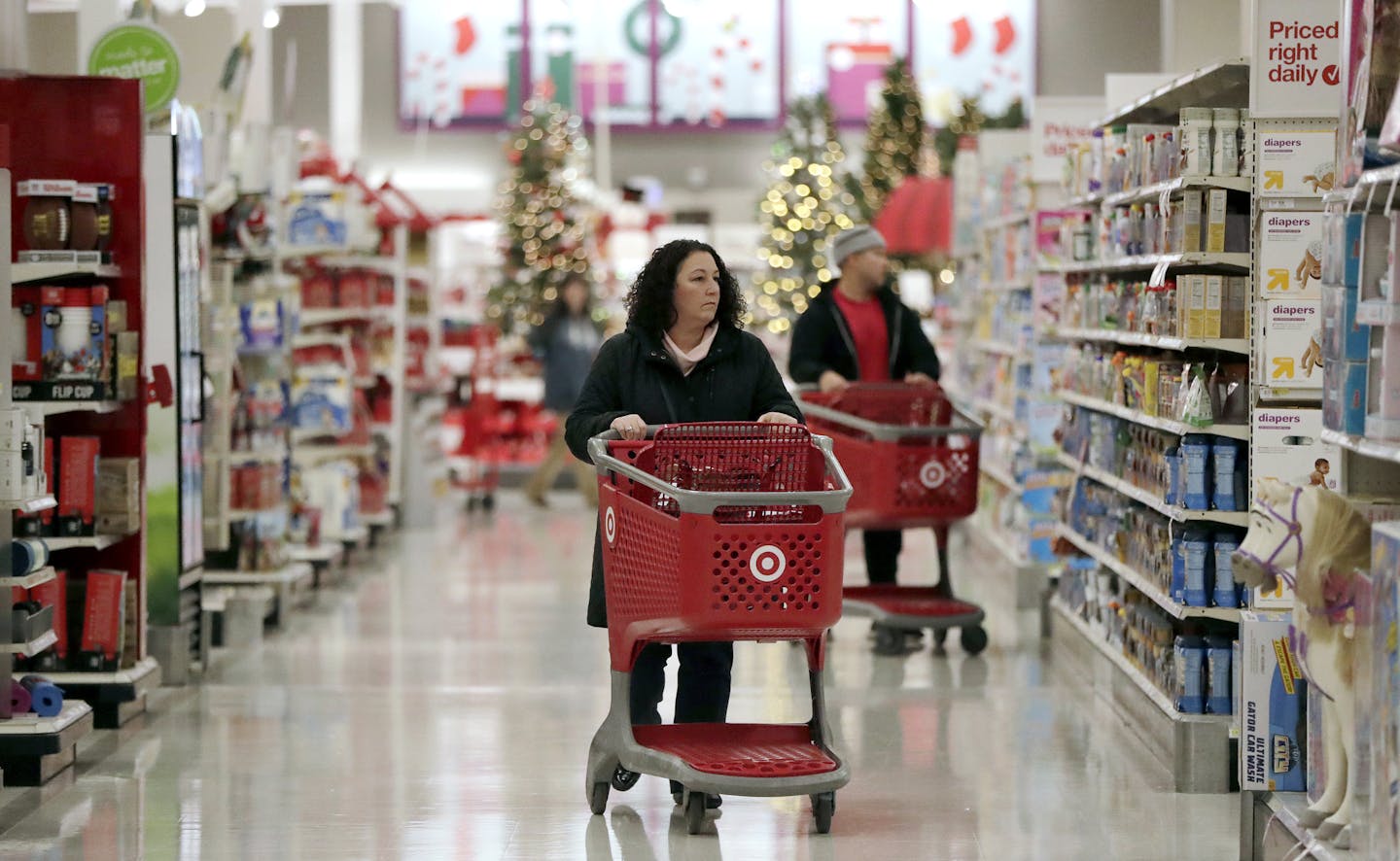 In this Friday, Nov. 16, 2018, photo, shoppers push carts while browsing isles at a Target store in Edison, N.J. Shoppers are spending freely heading into the holidays, but heavy investments and incentives like free shipping by retailers are giving Wall Street pause. Target Inc., Kohl's Corp., Best Buy Co. and TJX Cos. all reported strong sales at stores opened at least a year. (AP Photo/Julio Cortez)